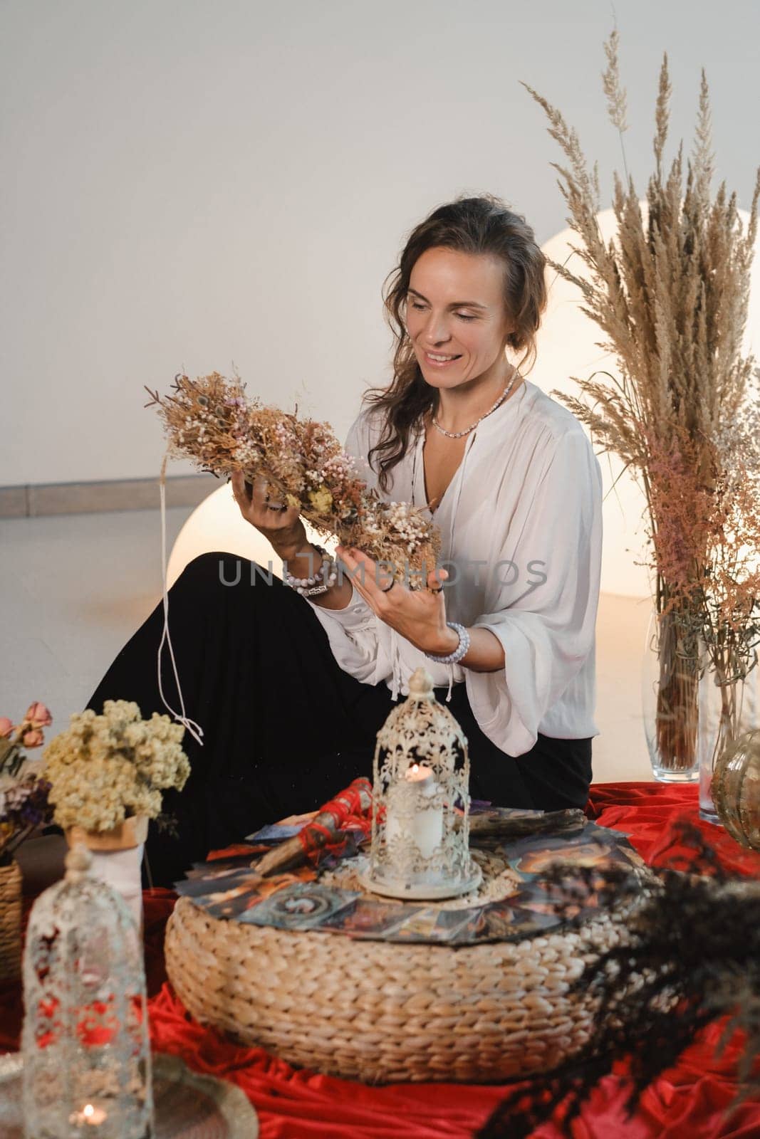 Women's circle and practice in the use of metaphorical cards. The girl is sitting surrounded by flowers.