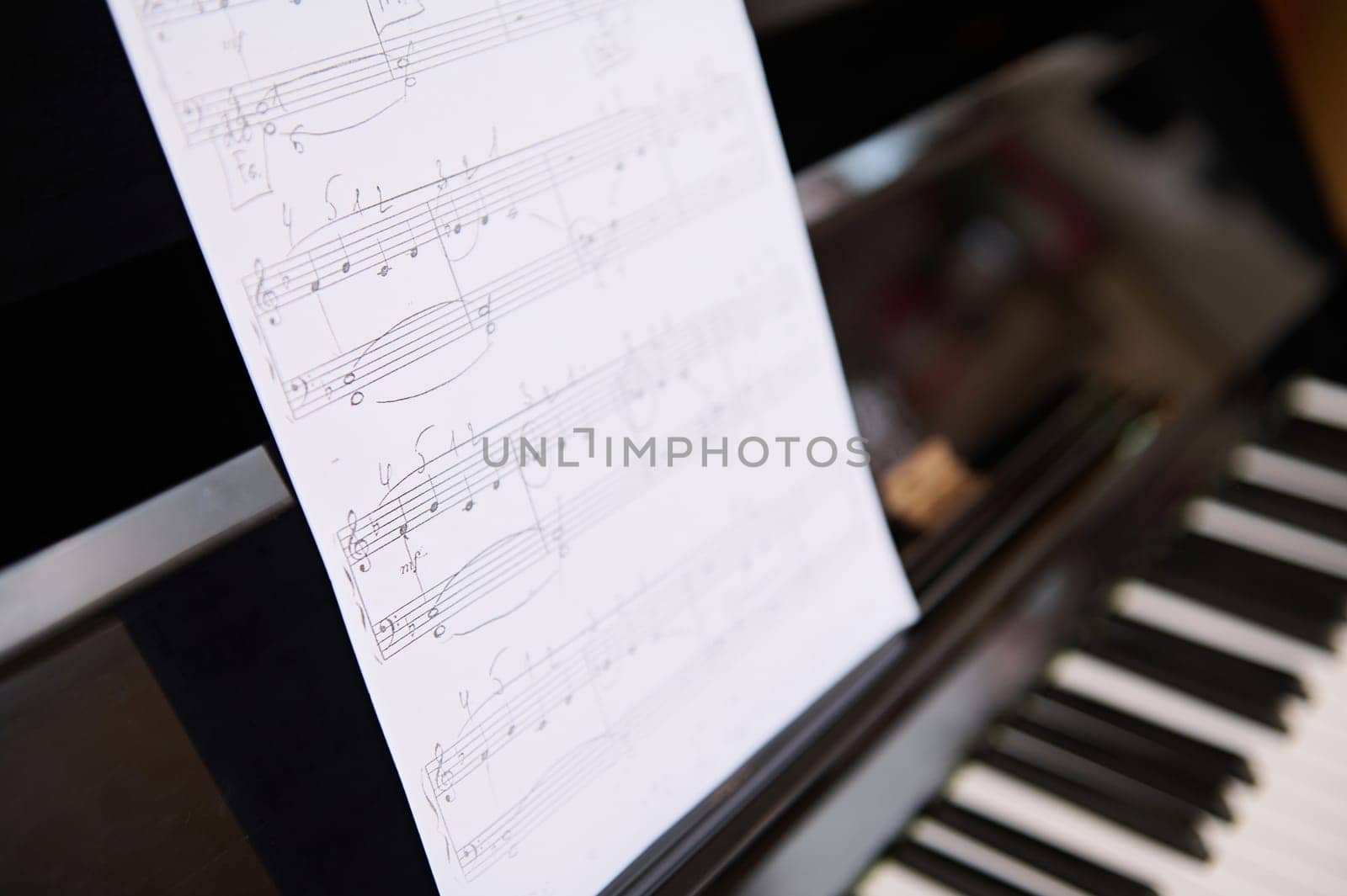Still life shot. Cropped View of old vintage classical wooden piano and music notes on white paper sheet. Chord music instrument