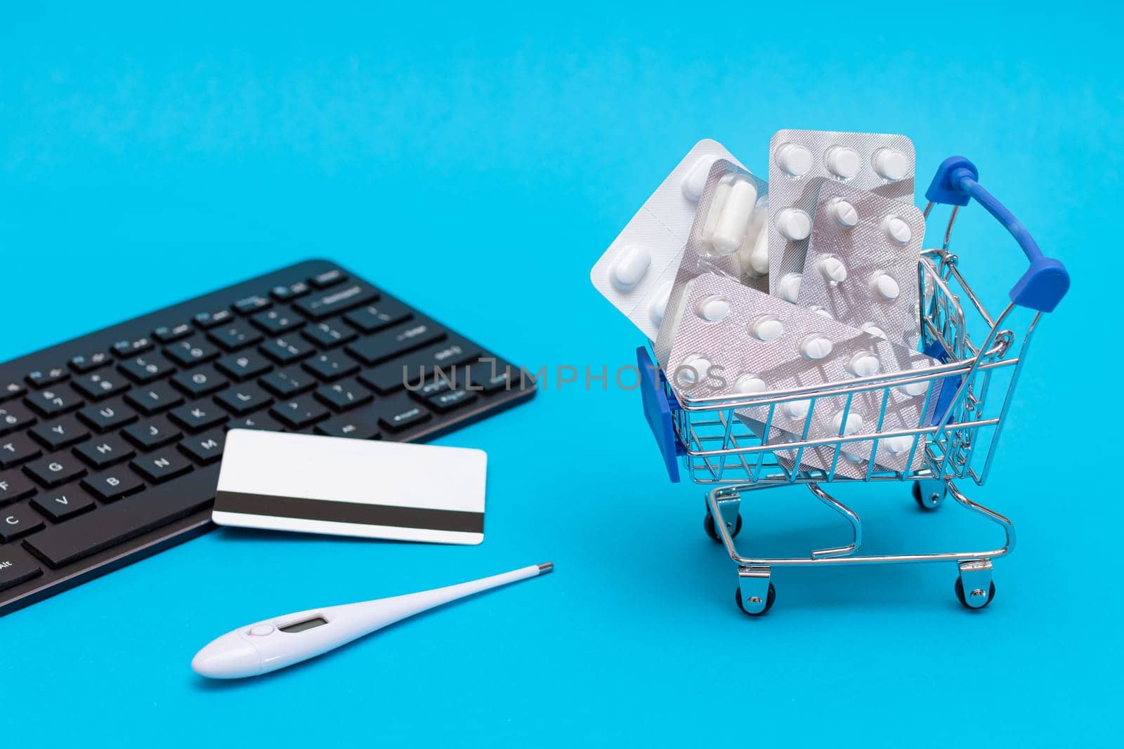 Ordering Medicines. Expensive Medicine and Inflation Concept: Pills and Capsules in a Shopping Cart on Blue Background. Global Pharmaceutical Industry and Big Pharma. Trade in Medicines