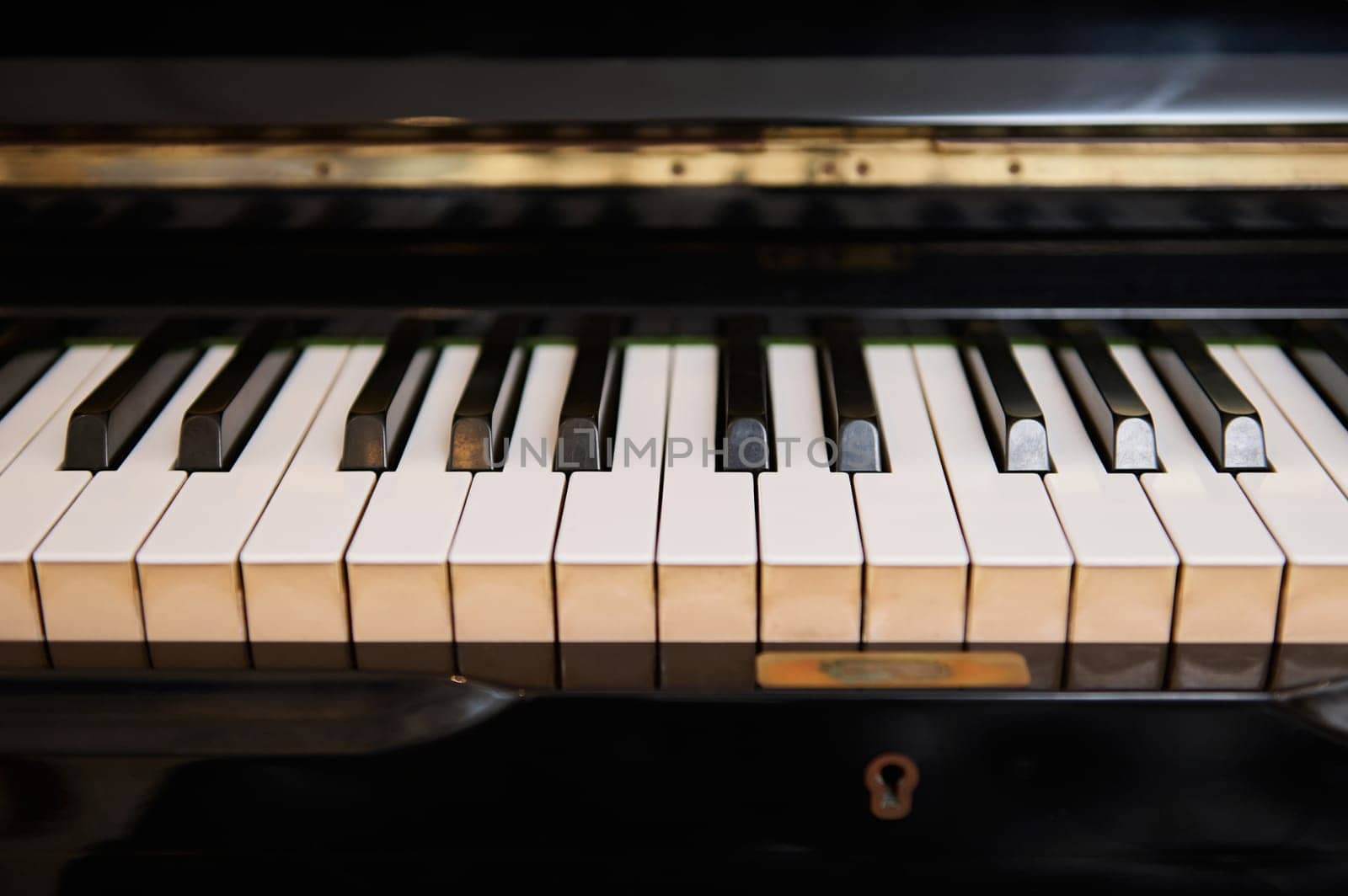 Close-up front view of classic grand piano keyboard. Ebony and ivory pianoforte keys. Chord musical instrument. Still life