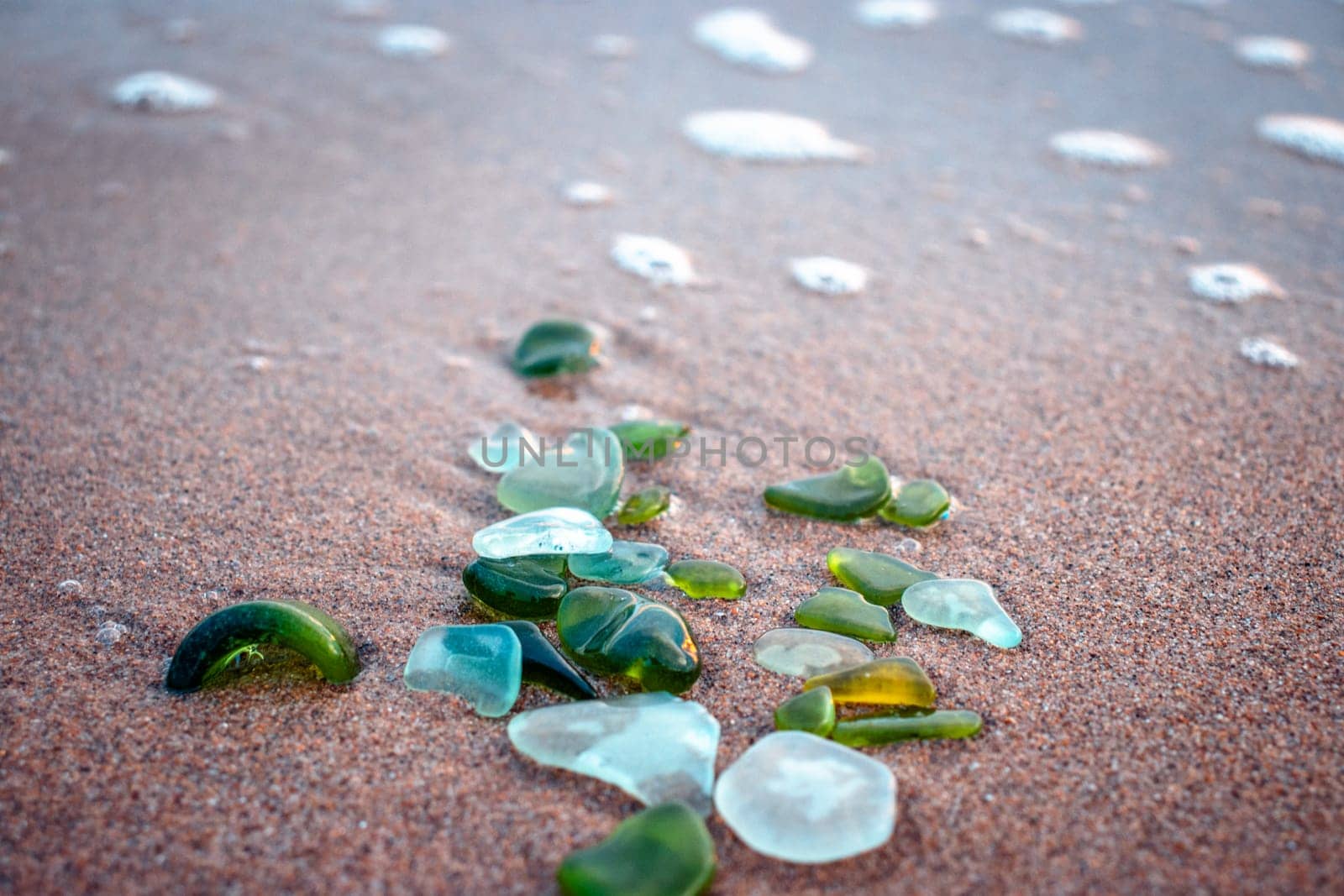 Sand beach and stones with foam concept photo. Glass stones from broken bottles polished by the sea. by _Nataly_Nati_