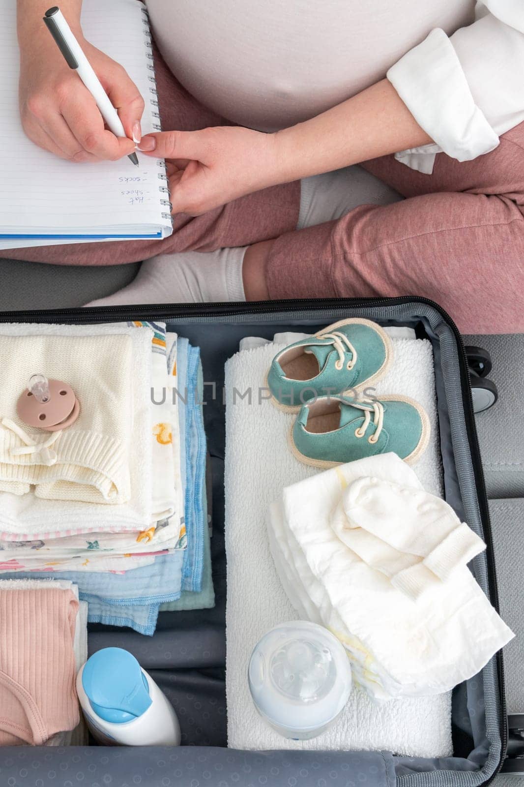 Captured moment of an expectant mother, pen in hand, listing essentials for her hospital stay, a