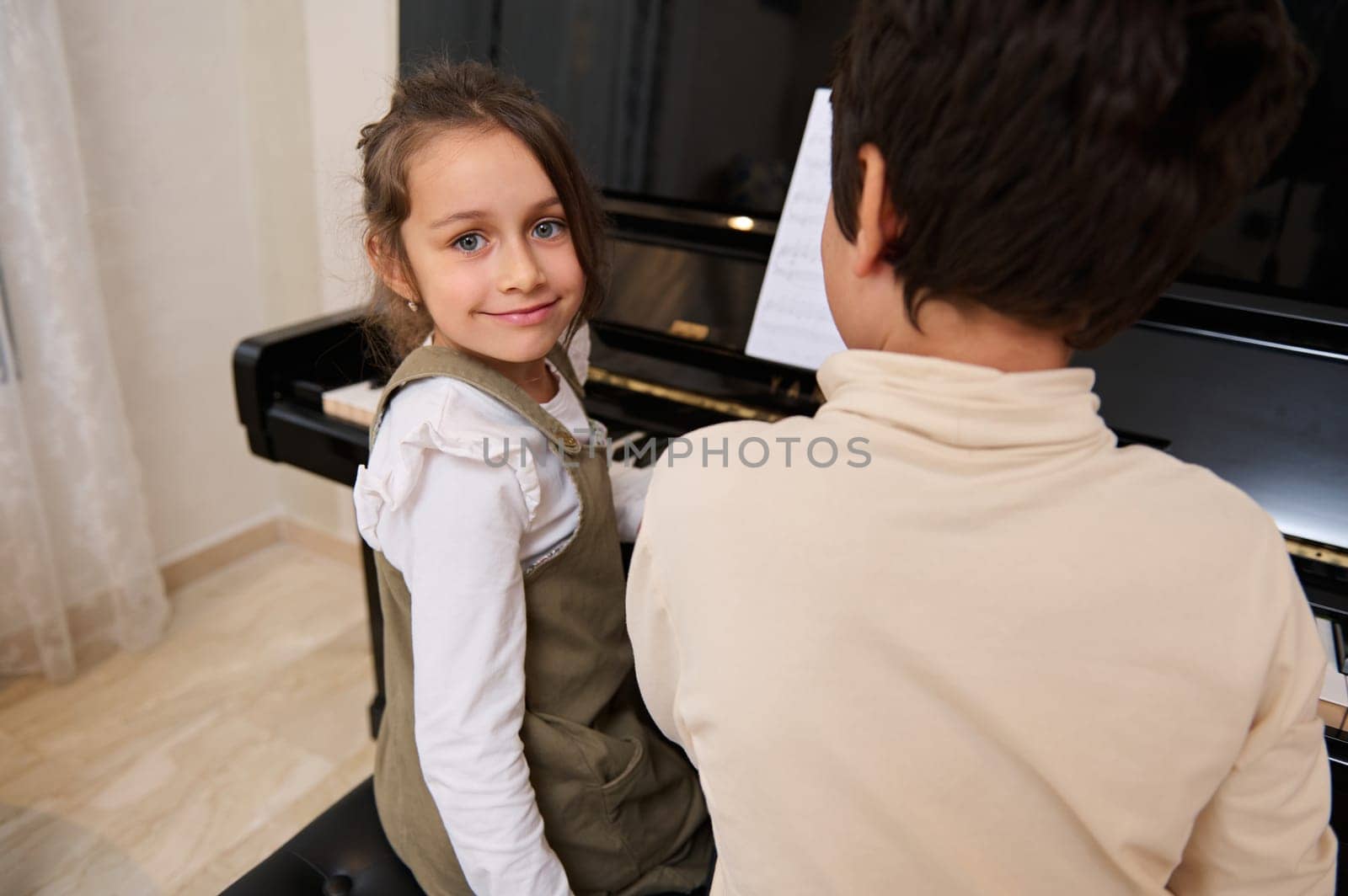 Handsome kids pianists playing grand piano, smiling looking at the camera. People. Culture. Arts. Education by artgf
