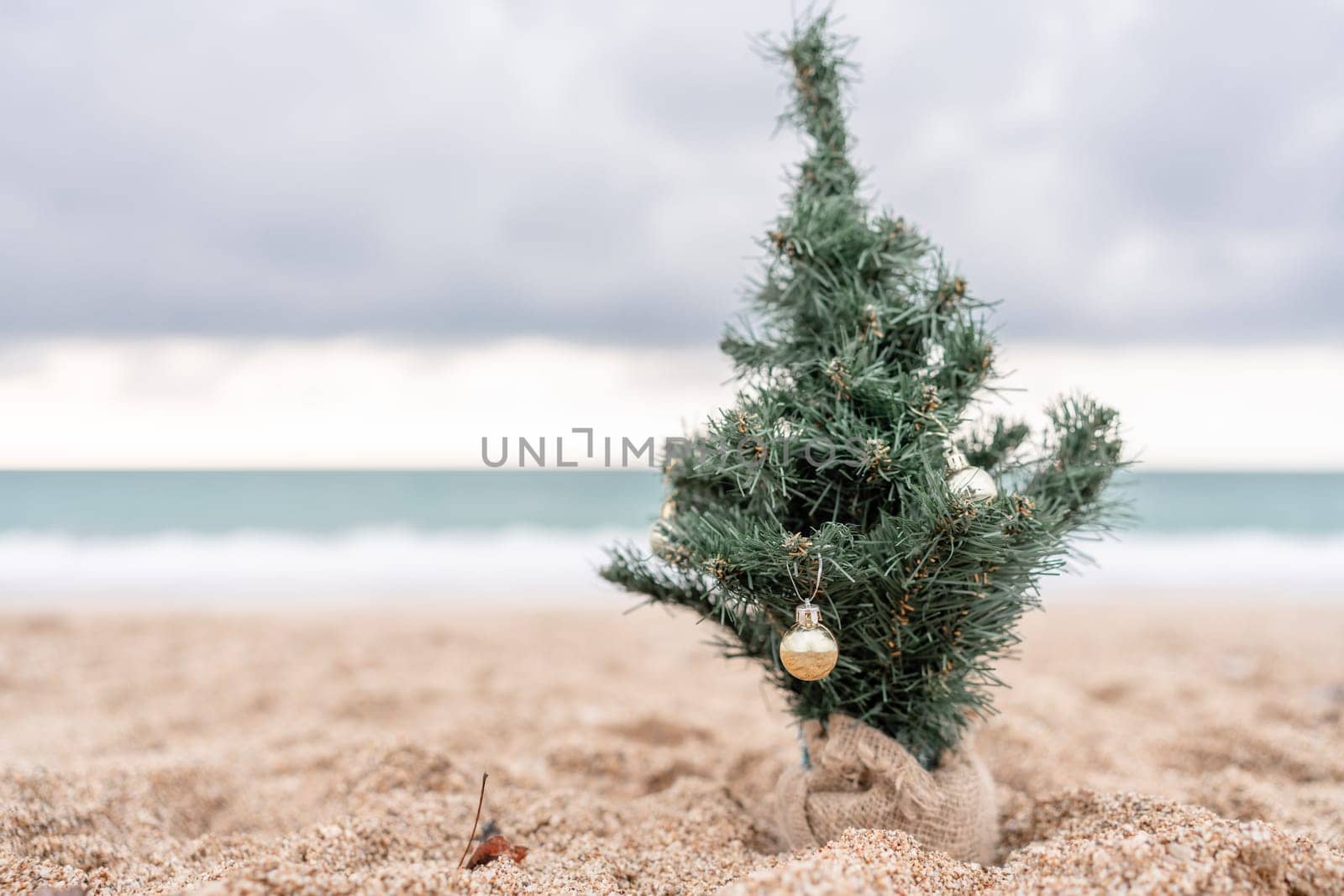 Sea Decorated Christmas tree on sandy beach. Christmas, New Year holidays concep