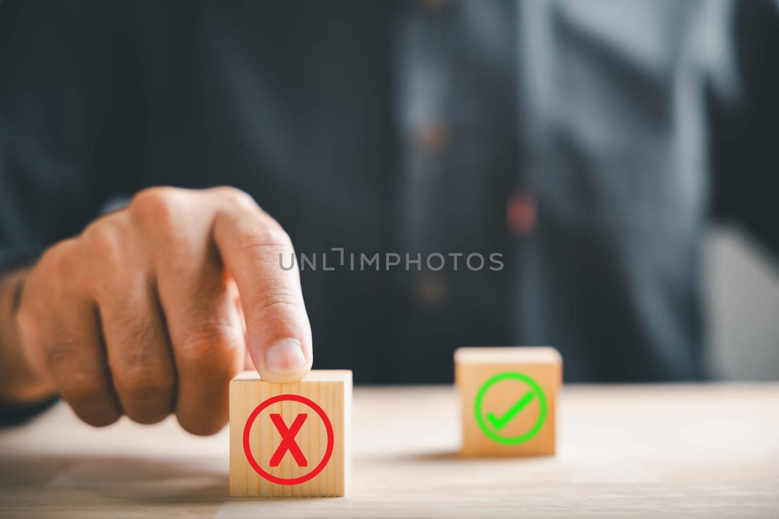 Businessman finger touches wooden cubes with wrong cross X for right. Shows communication of choice validation in decision-making. Think With Yes Or No Choice.