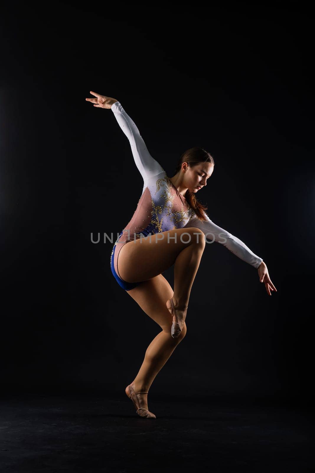 Beautiful ballet dancer sport aerobics female posing on white and black studio background by Zelenin