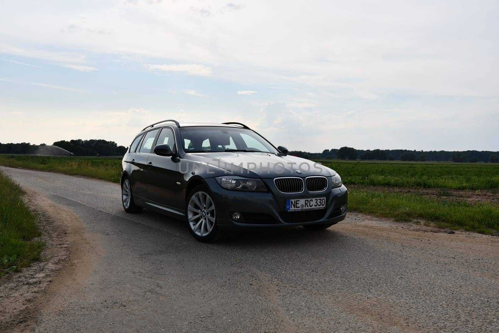 BMW 330d, E91, touring green-gray station wagon on country lane by rherrmannde