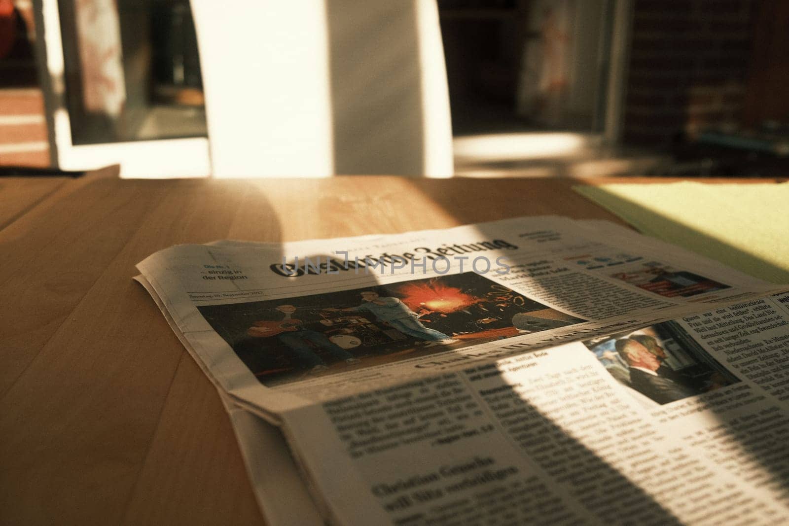 High-angle view of Goslarsche Zeitung newspaper on a wooden surface under the sunlight by rherrmannde
