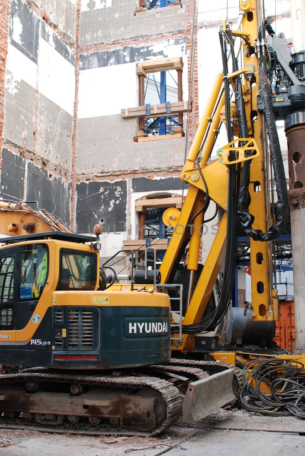 Yellow excavator from Hyundai inside a demolition house in Hamburg at the inner Alster lake