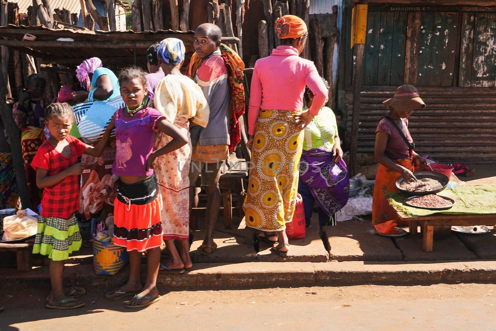 Toliara, Madagascar - May 05, 2019: Unknown Malagasy locals buying food at street market on sunny day. There are not many shops, goods are usually sold by the road in this region.