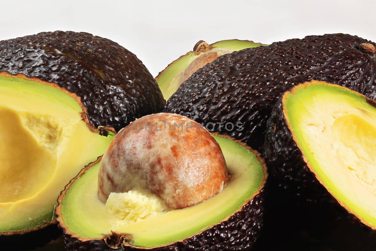 Closeup detail of avocado - Hass / Bilse variety - pit visible in halved pears