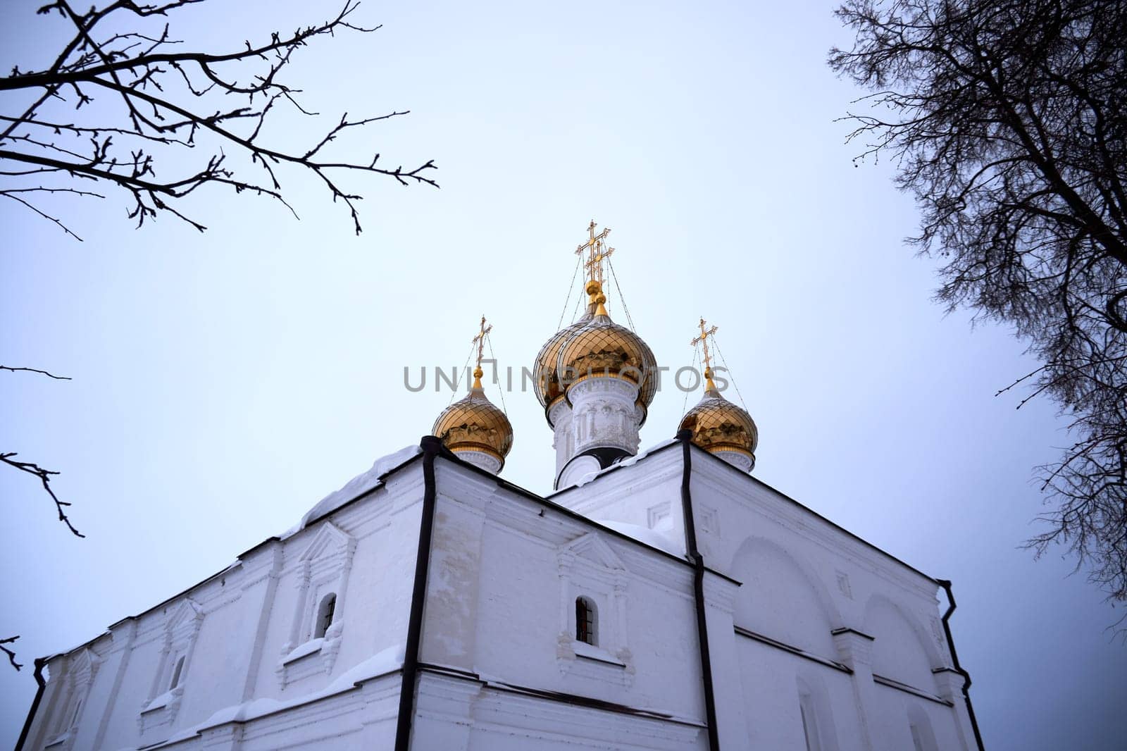 Golden domes with crosses of the Russian church against the sky