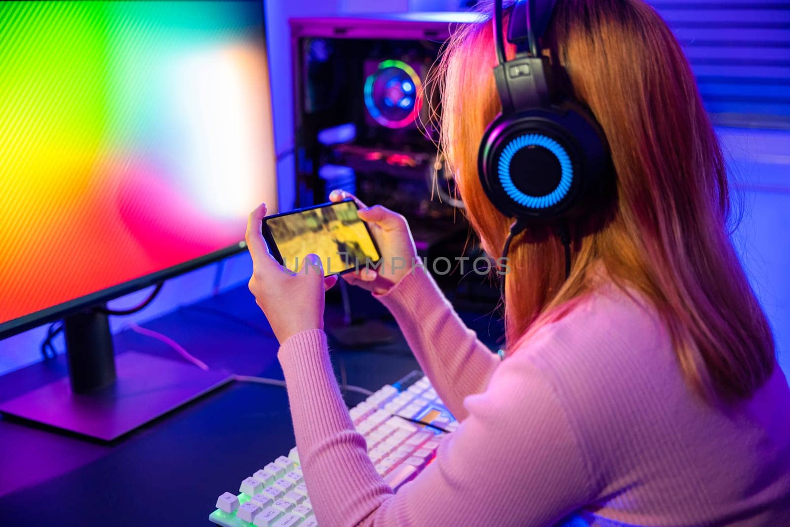Asian woman live stream she play video game via smartphone at home neon lights living room by Sorapop
