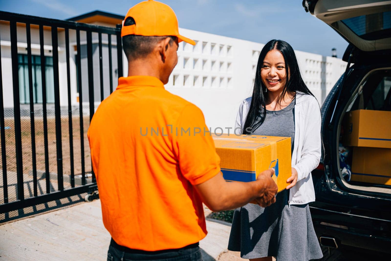 Efficient home delivery logistics depicted as a courier delivers a cardboard parcel to a smiling woman by Sorapop