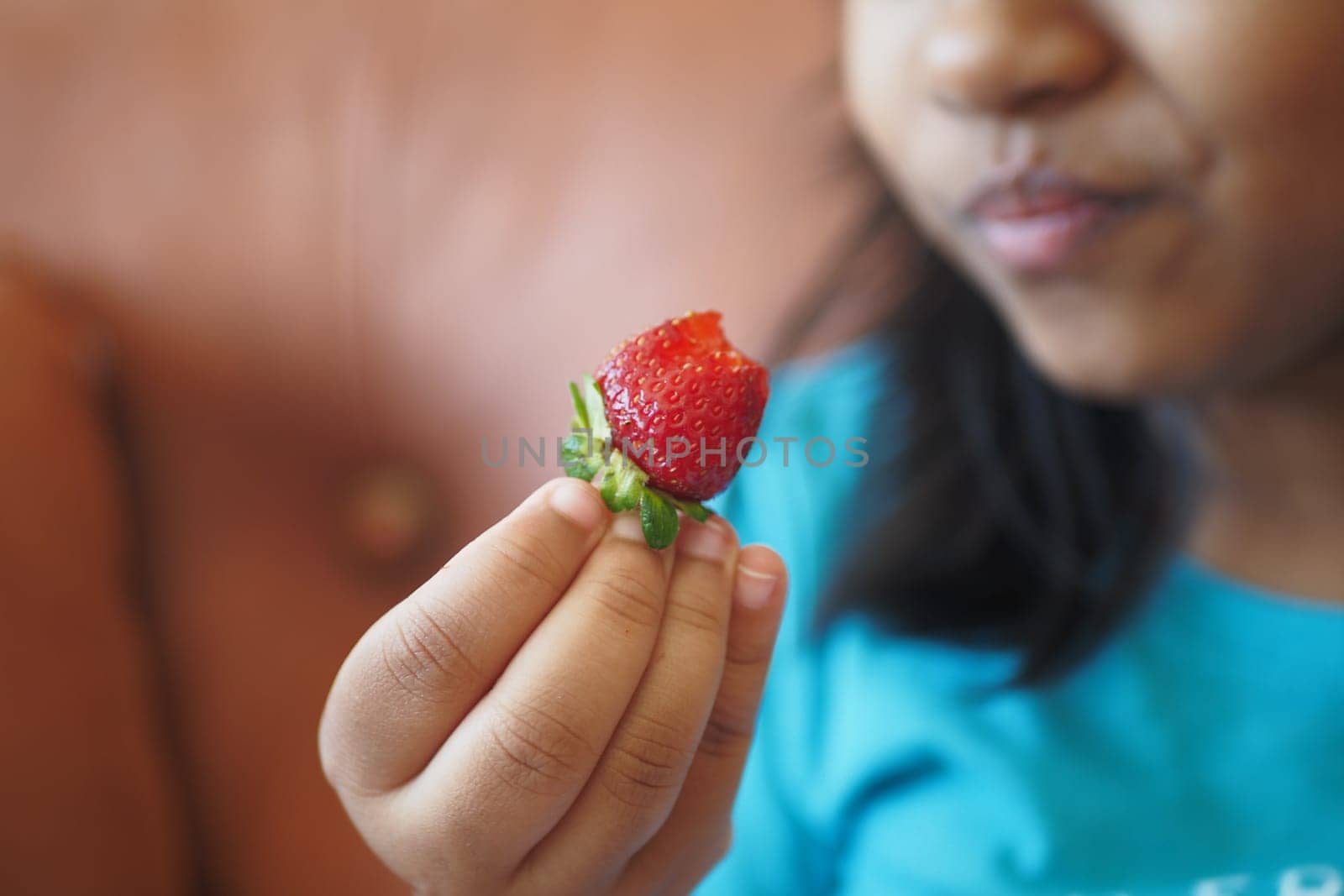 child eating Strawberries sitting on sofa by towfiq007