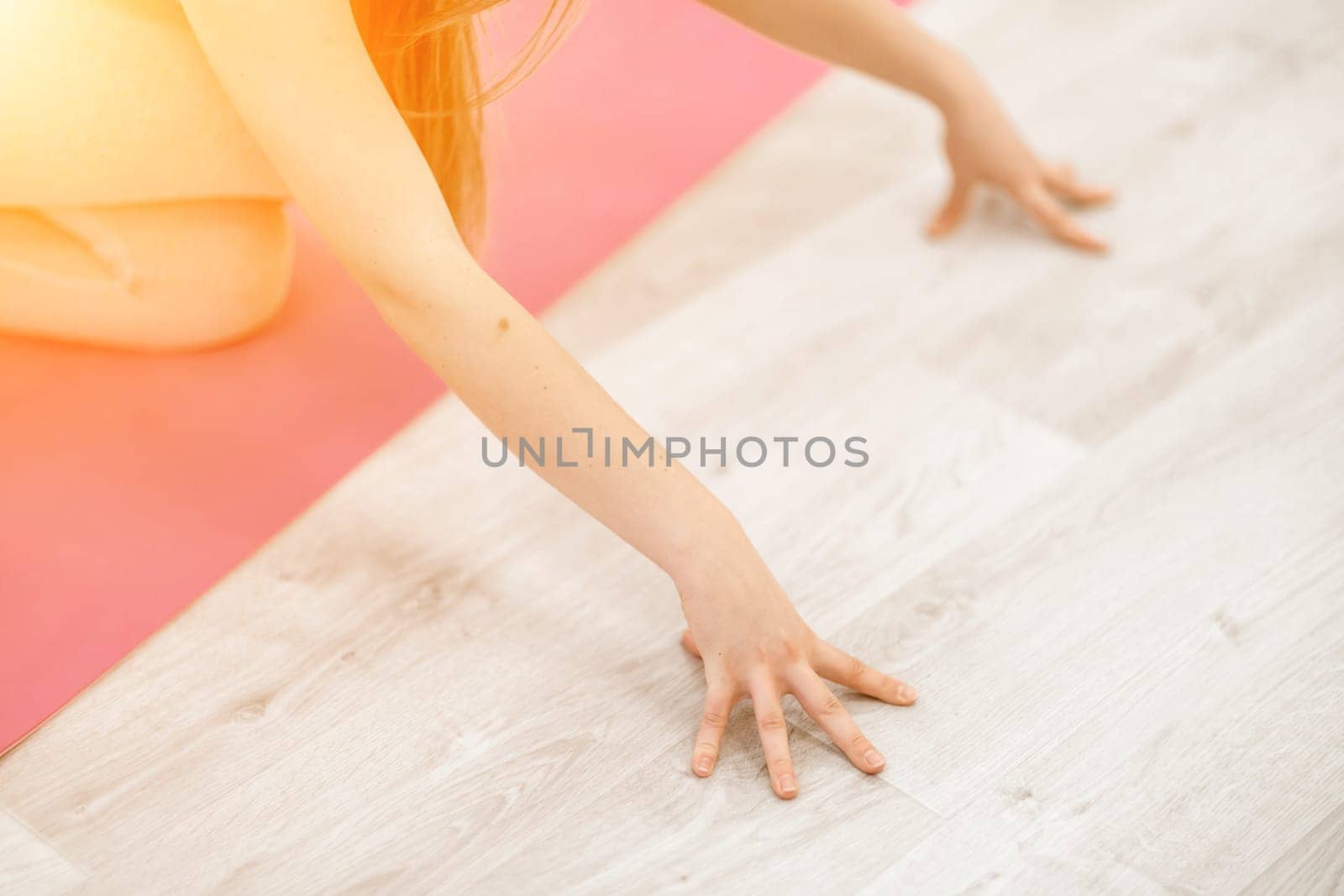 Girl does yoga. Young woman practices asanas on a beige one-ton background. by Matiunina