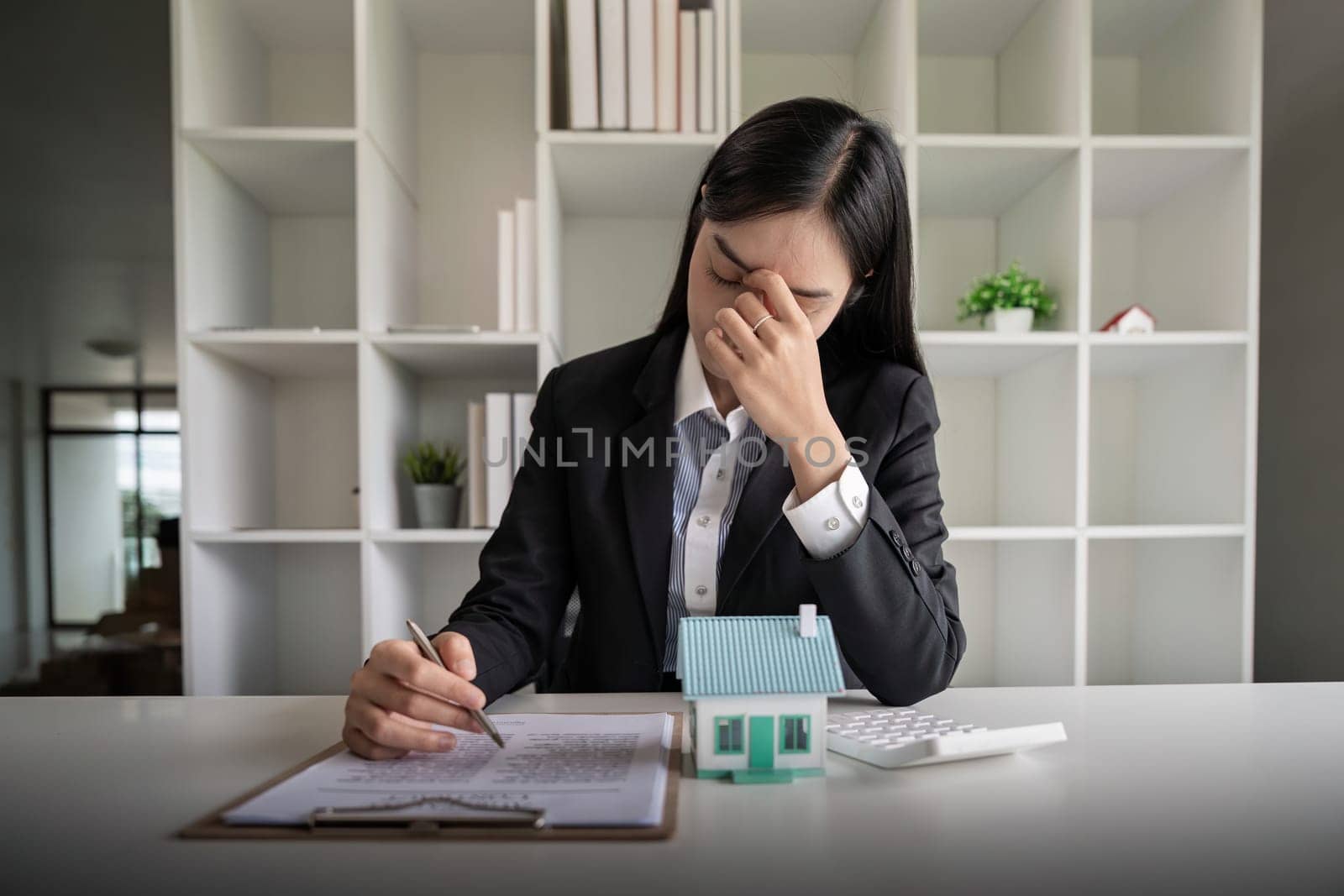 Asia Business woman stress from work investment in real estate, There are financial problem with installments with the bank.