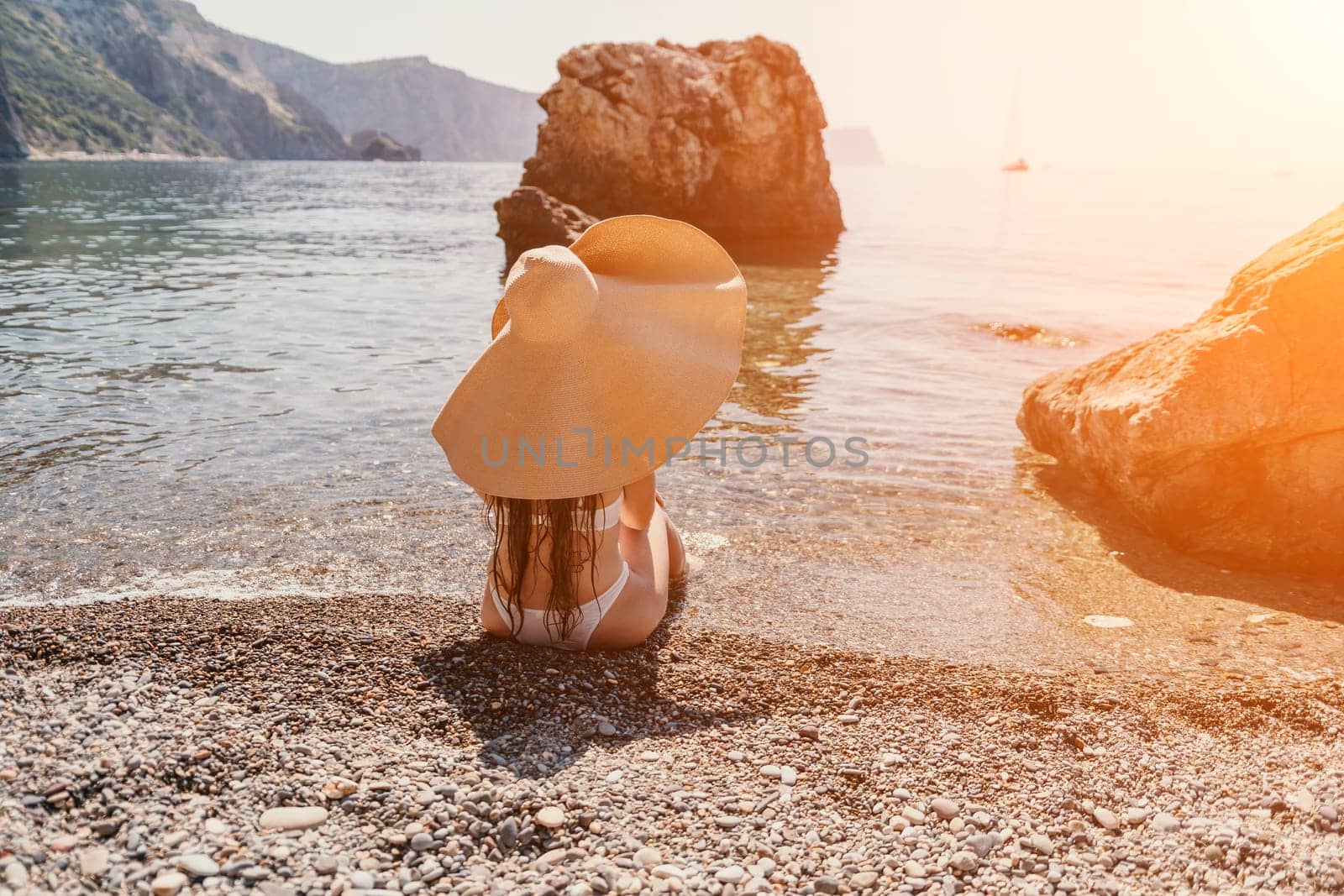 Woman travel sea. Happy tourist in hat enjoy taking picture outdoors for memories. Woman traveler posing on the beach at sea surrounded by volcanic mountains, sharing travel adventure journey by panophotograph