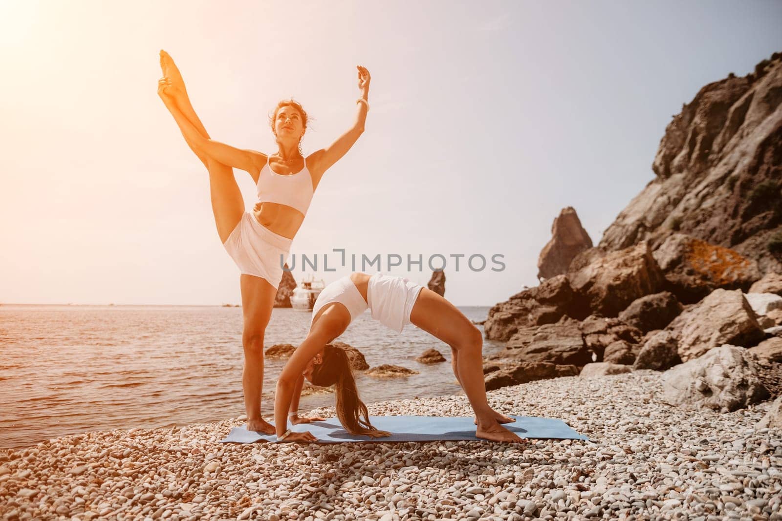 Woman sea yoga. Back view of free calm happy satisfied woman with long hair standing on top rock with yoga position against of sky by the sea. Healthy lifestyle outdoors in nature, fitness concept.