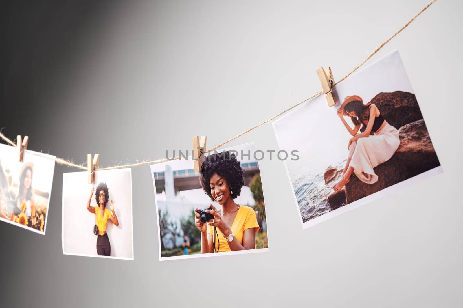 Printed colorful photos of women portraits against gray background close up