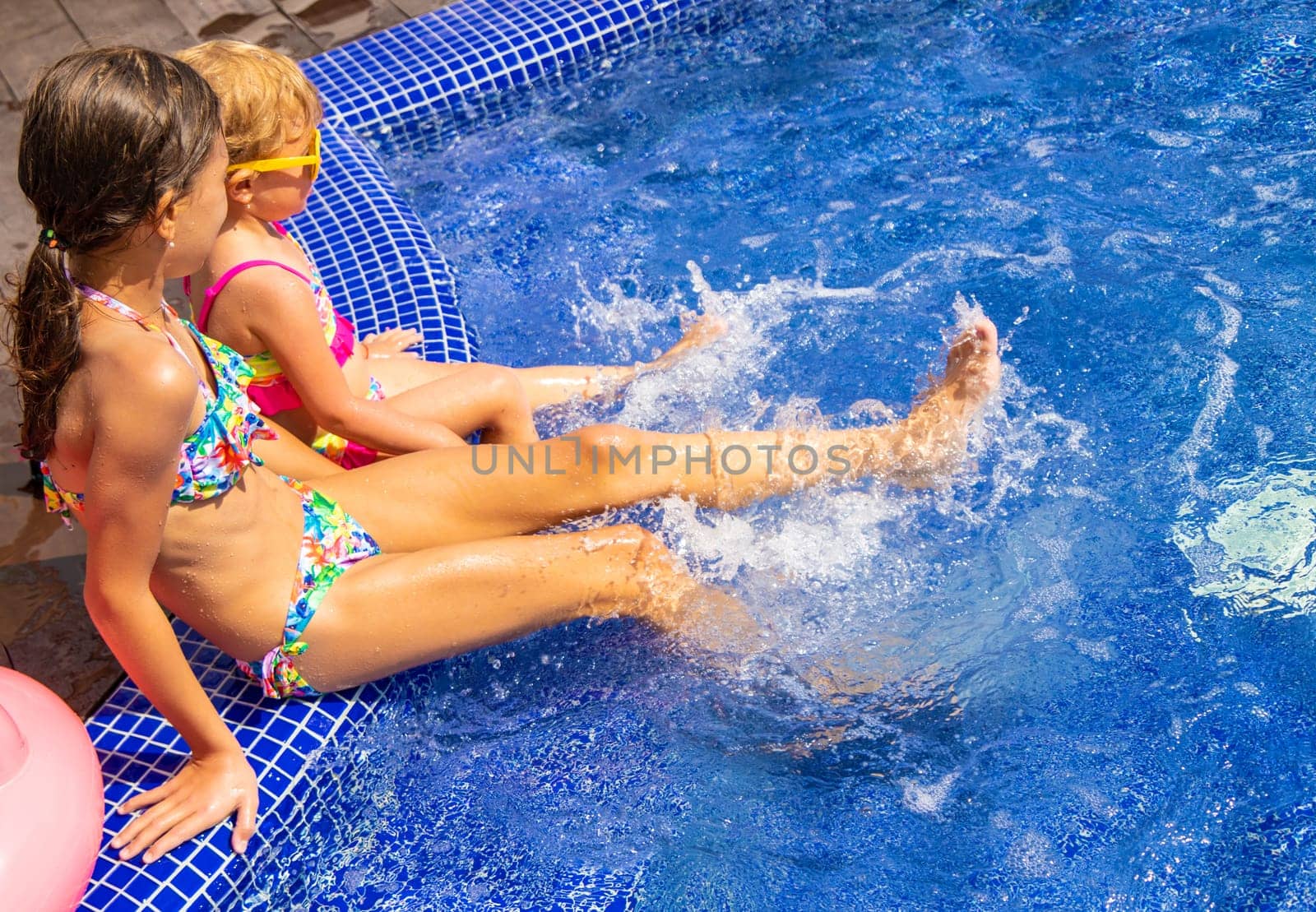 Child near the pool in sunglasses. Selective focus. by yanadjana