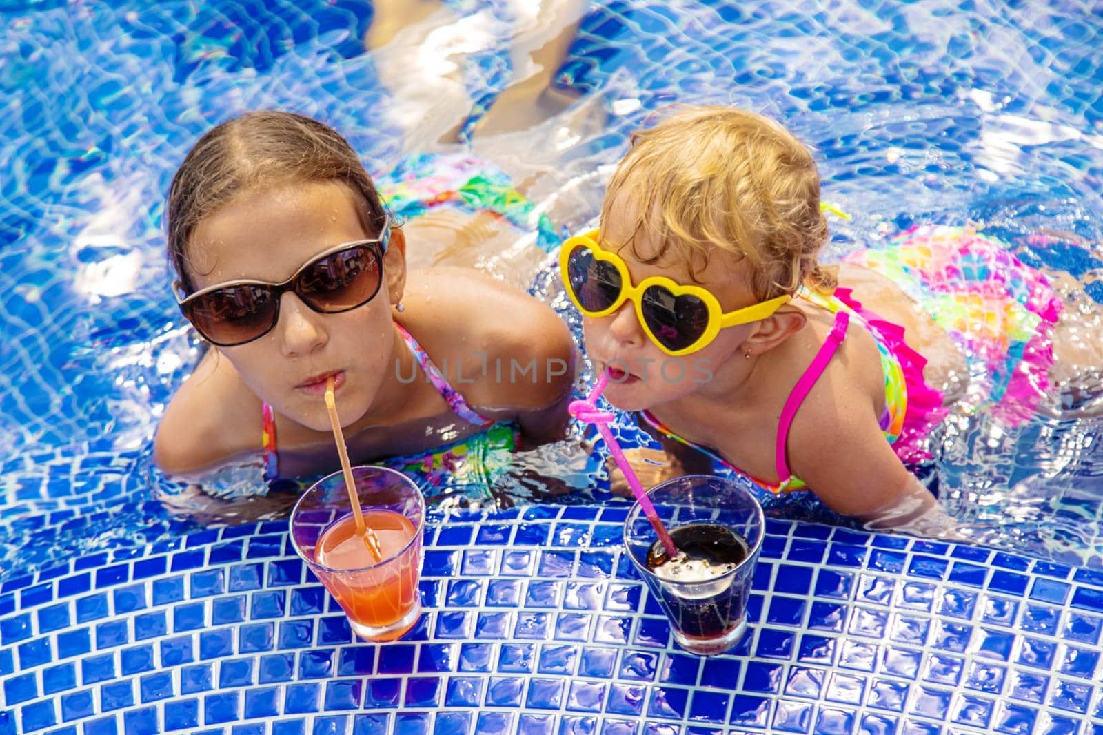 Children drink a cocktail in the pool. Selective focus. Kids.