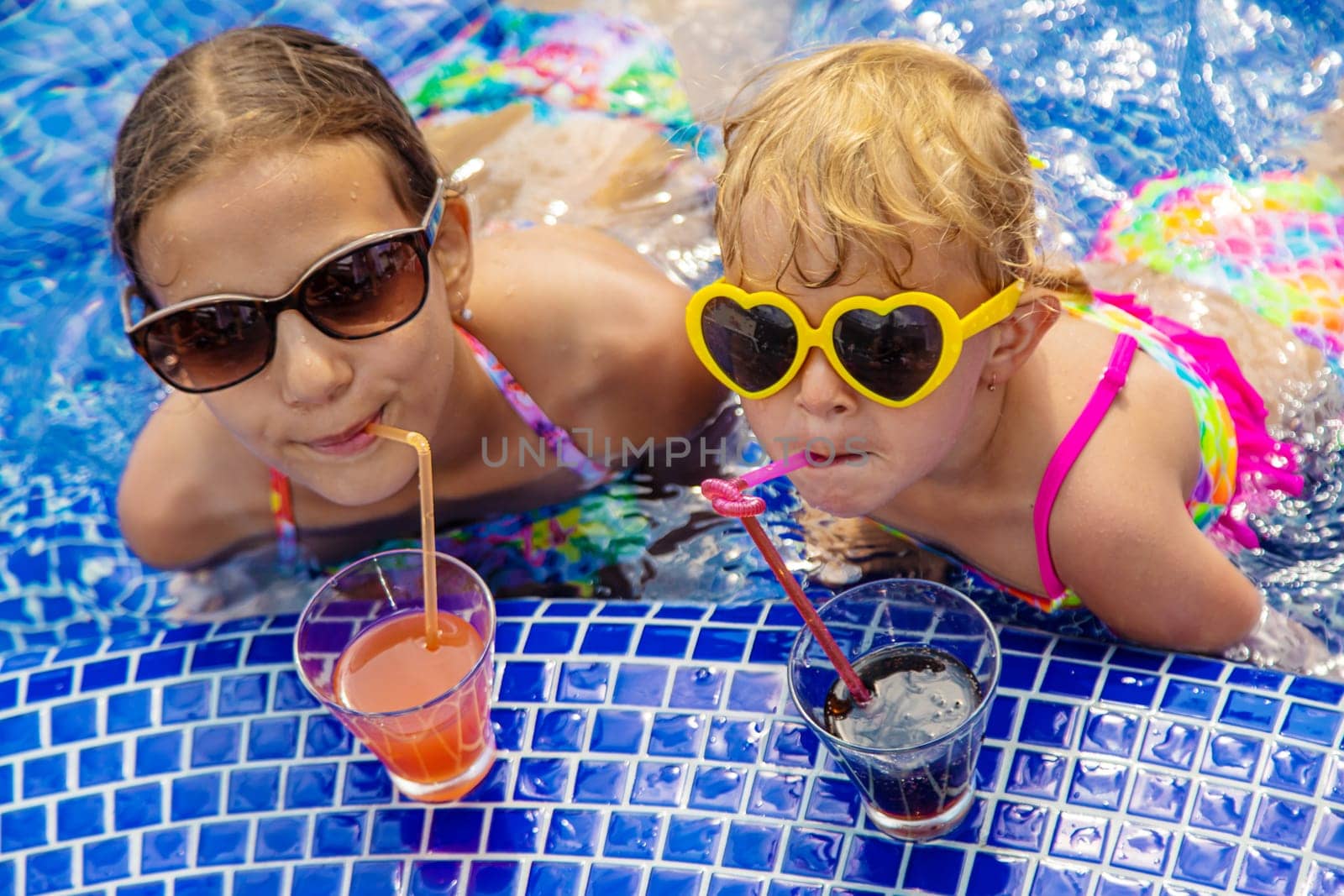 Children drink a cocktail in the pool. Selective focus. Kids.