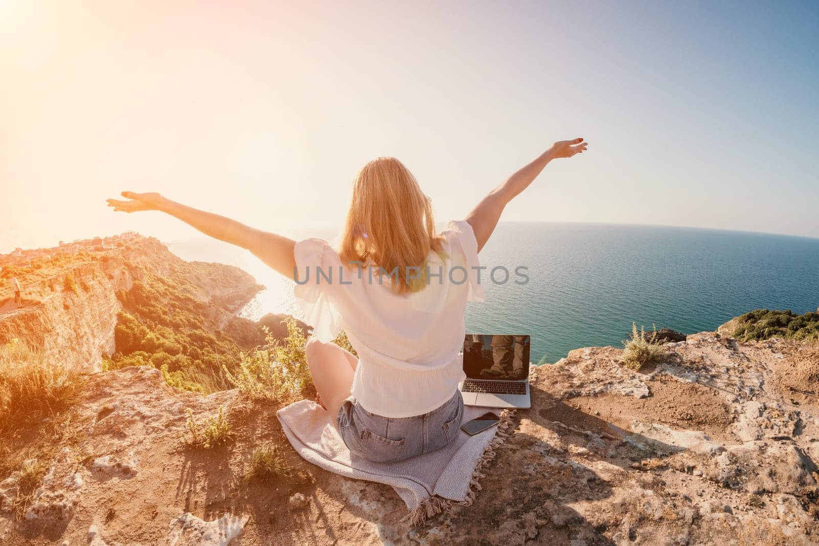 Woman sea laptop. Business woman working on laptop by sea at sunset. Close up on hands of pretty lady typing on computer outdoors summer day. Freelance, digital nomad, travel and holidays concept. by panophotograph