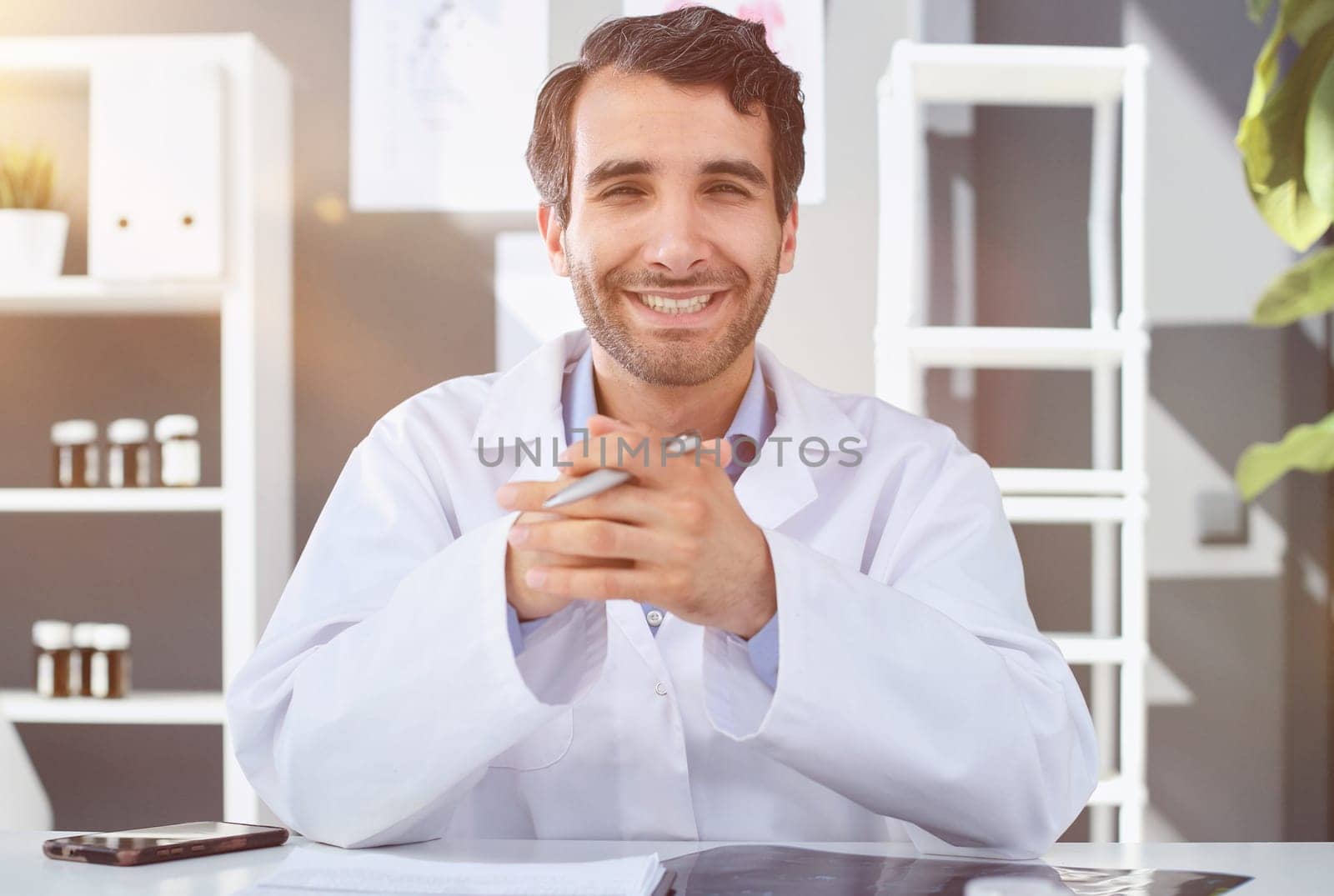 Portrait of confident doctor at desk in his medical practice
