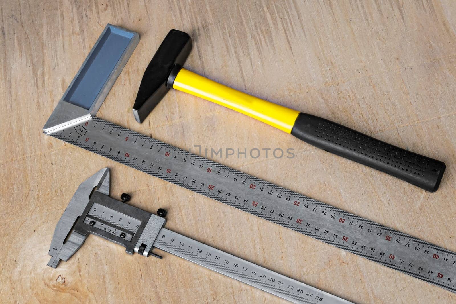 On the table prepared to work tools: hammer, square, ruler, caliper
