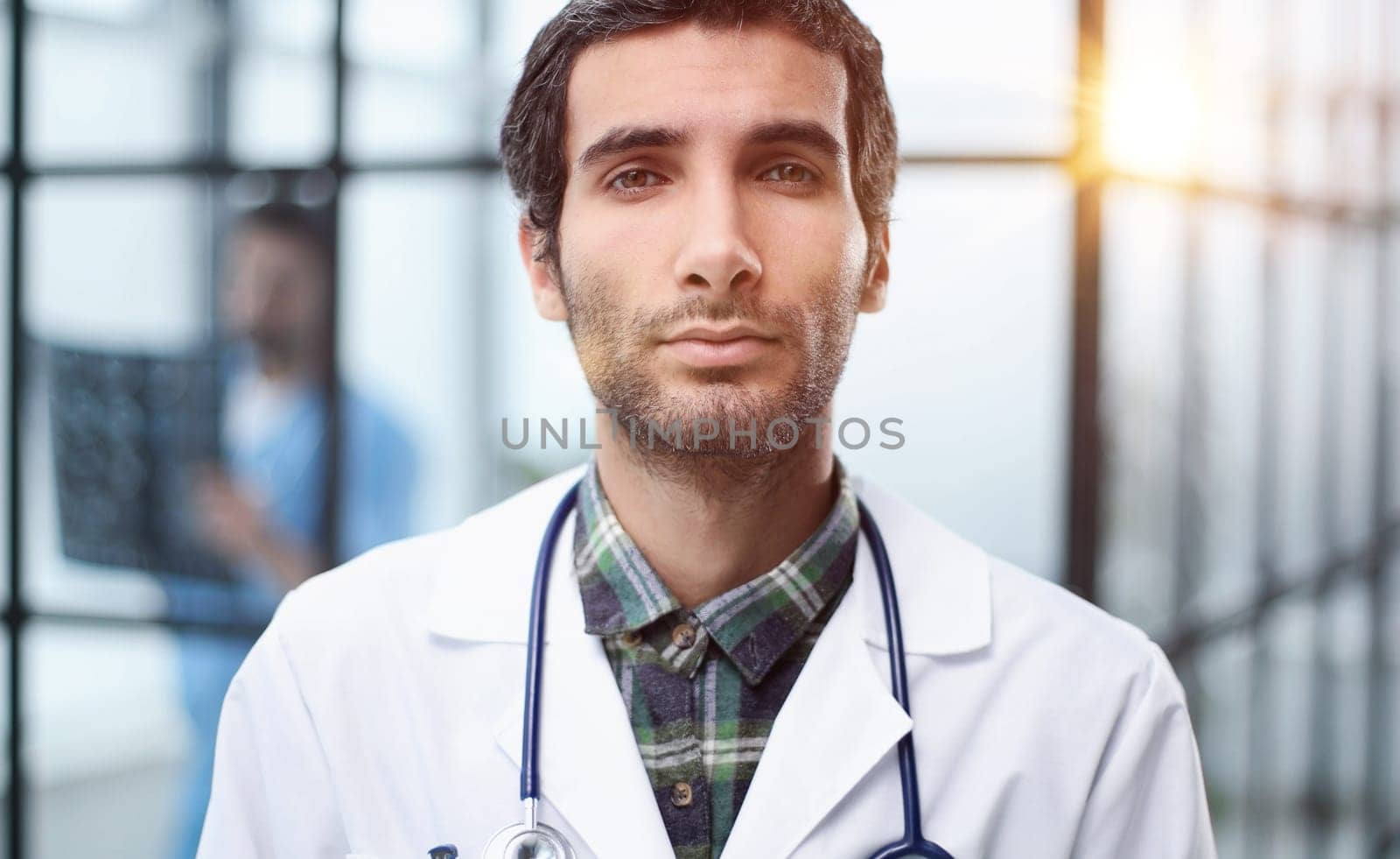 Headshot portrait male doctor or therapist in white medical uniform, glasses and stethoscope,