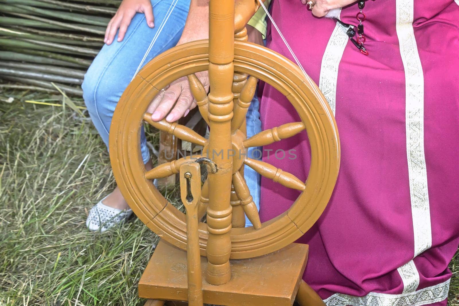 Old wooden spinning wheels and a woman in national dress. by georgina198