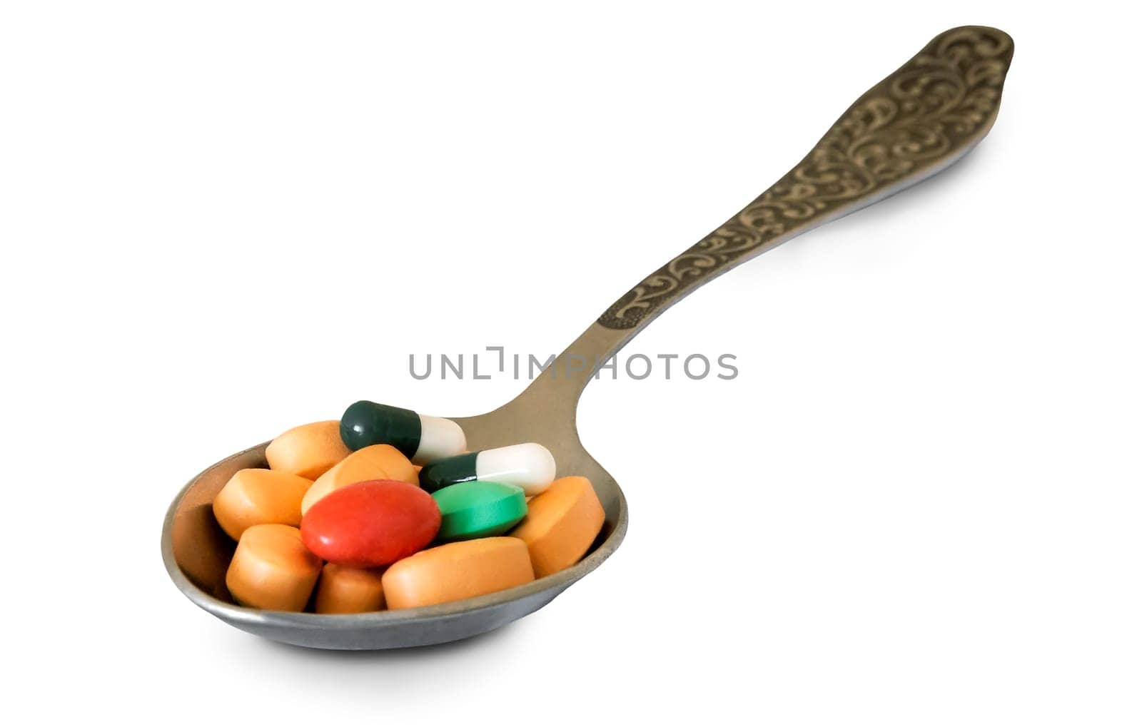 In a metal spoon different medications in pill form. Presented on a white background.