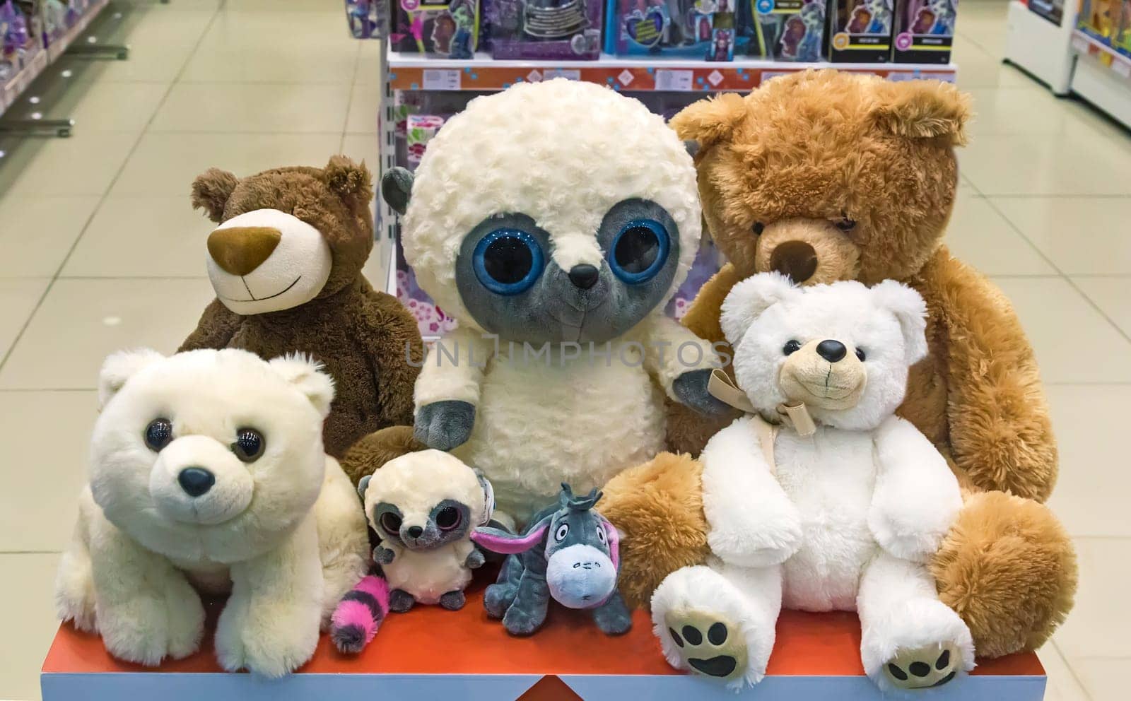 Various children's soft toys: bear , dog and others on the storefront.