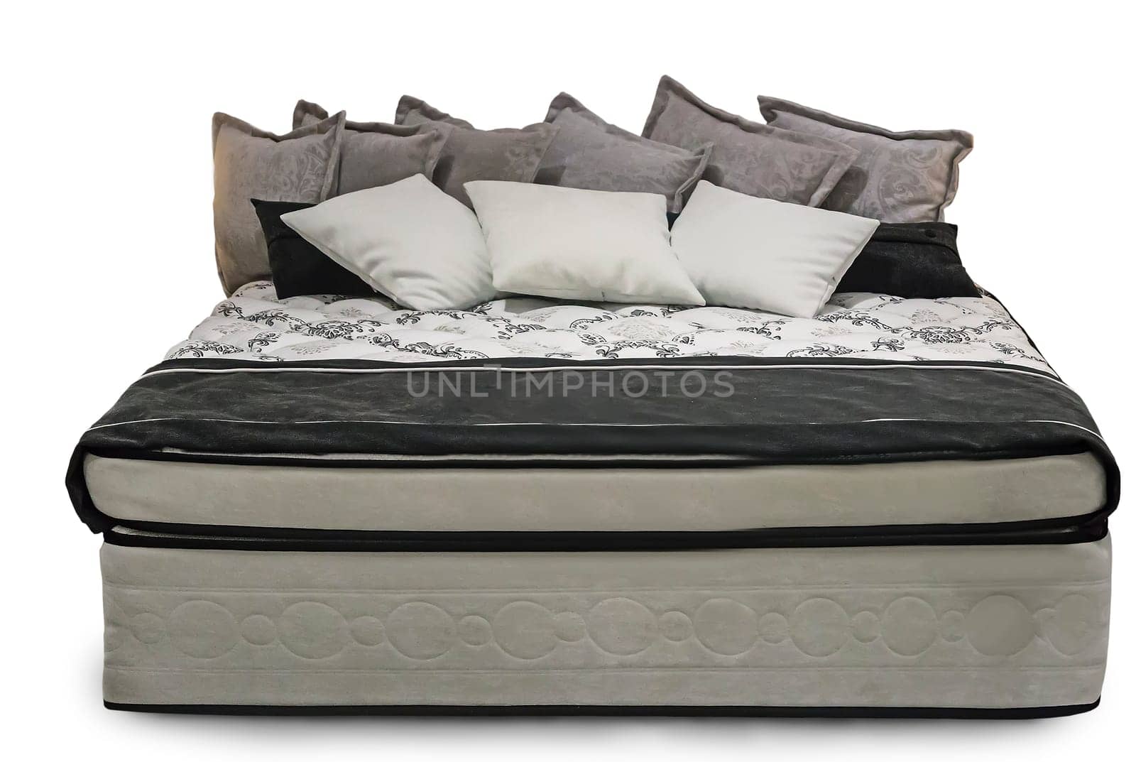 Comfortable double bed with beautiful bedspread and pillows. Presented on a white background.