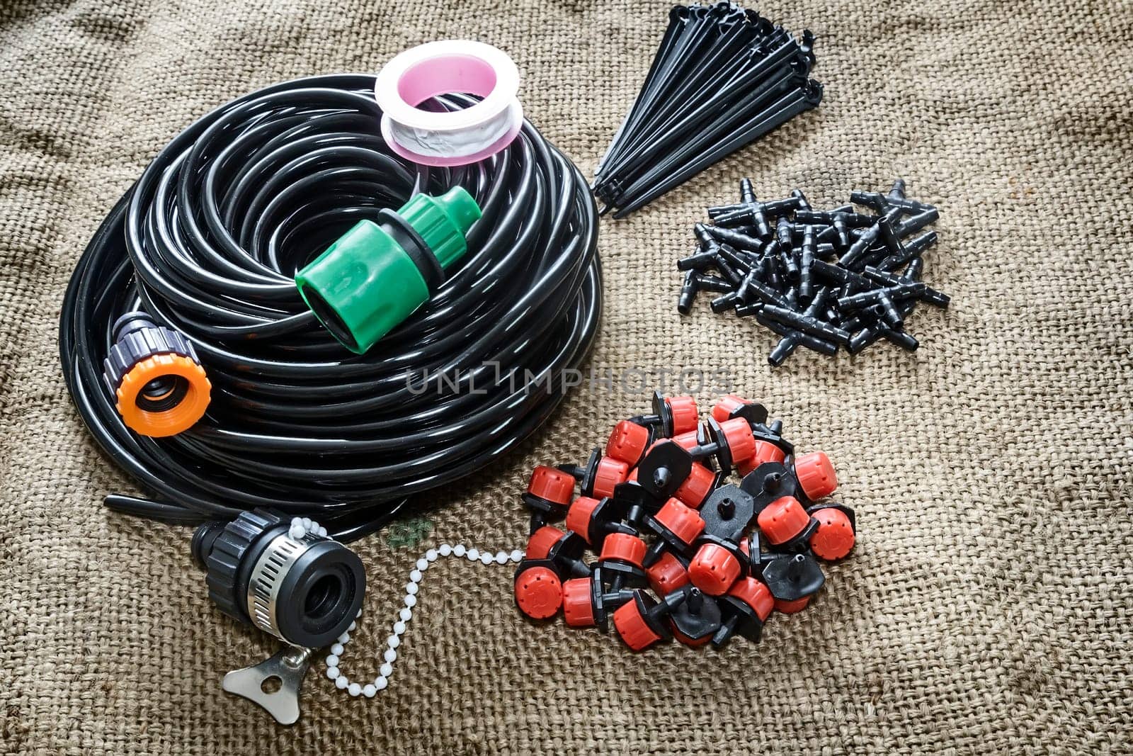 A set of tools for drip irrigation of plants and garden: hose, sprinklers, joints, hose holders.