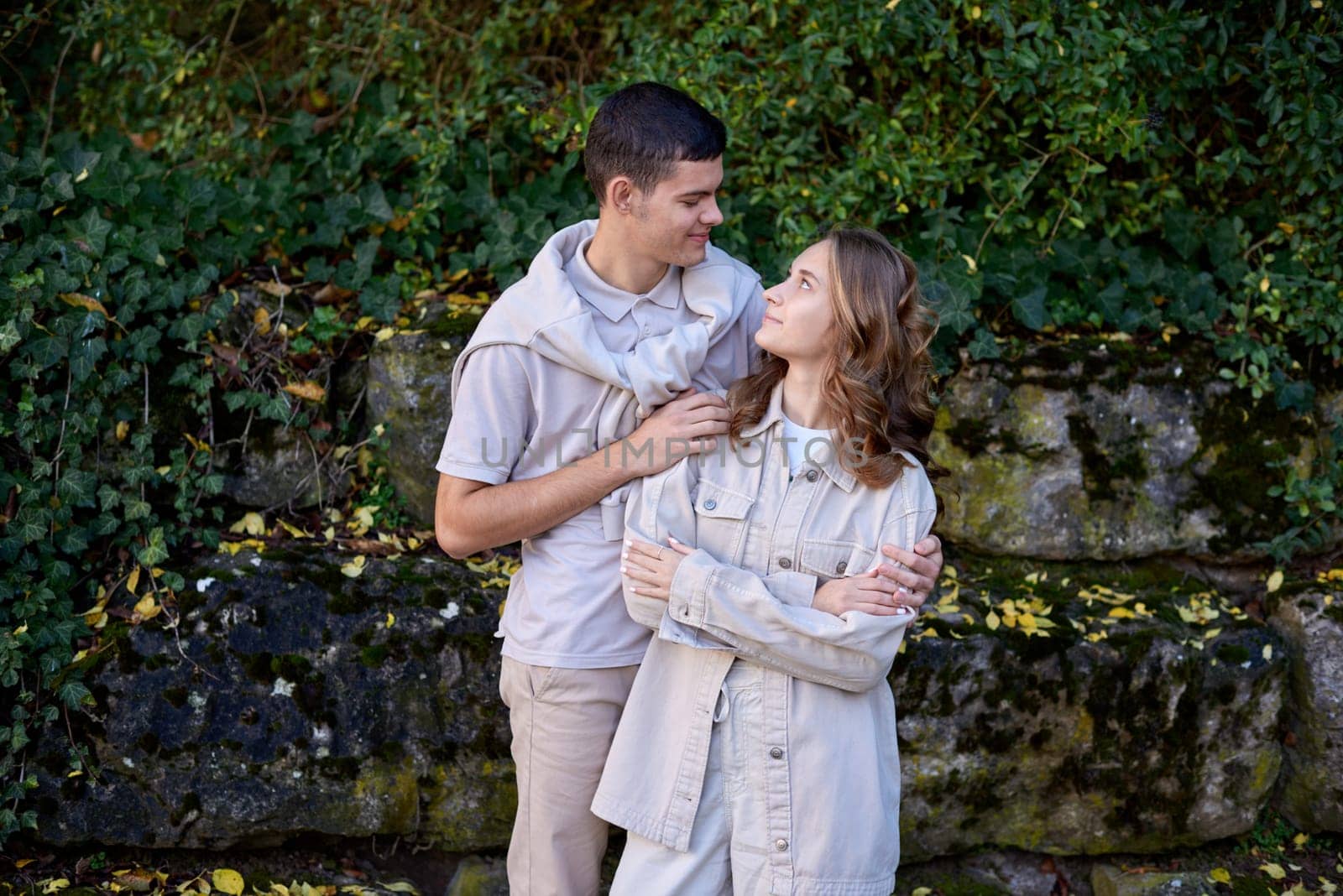 Young Cute Female Hugs Boyfriend. In Autumn Outdoor. Lovers Walking in Park. Attractive Funny Couple. Lovestory in Forest. Man and Woman. Cute Lovers in the Park. Family Concept. Happy Couple.