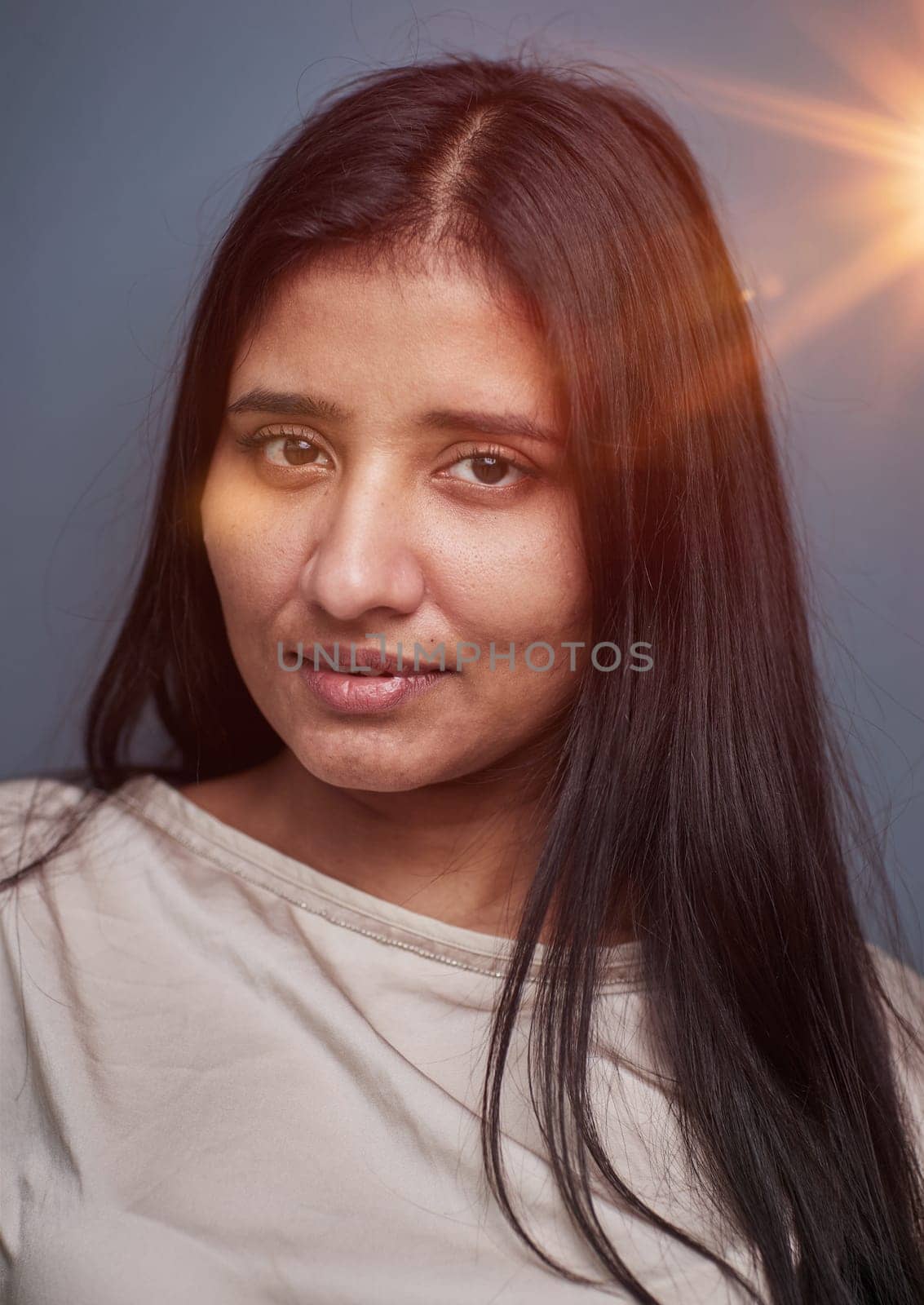 Portrait of beautiful young woman standing on grey background by Prosto