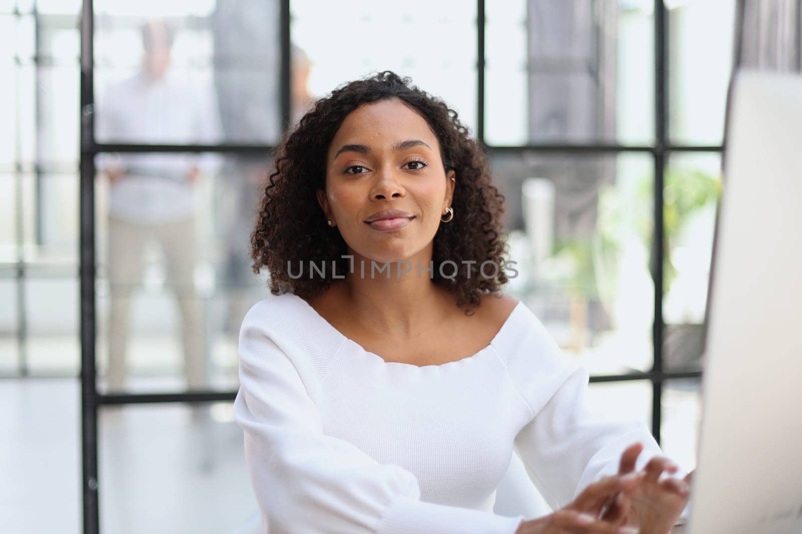 Portrait of a confident businesswoman with team in the background by Prosto