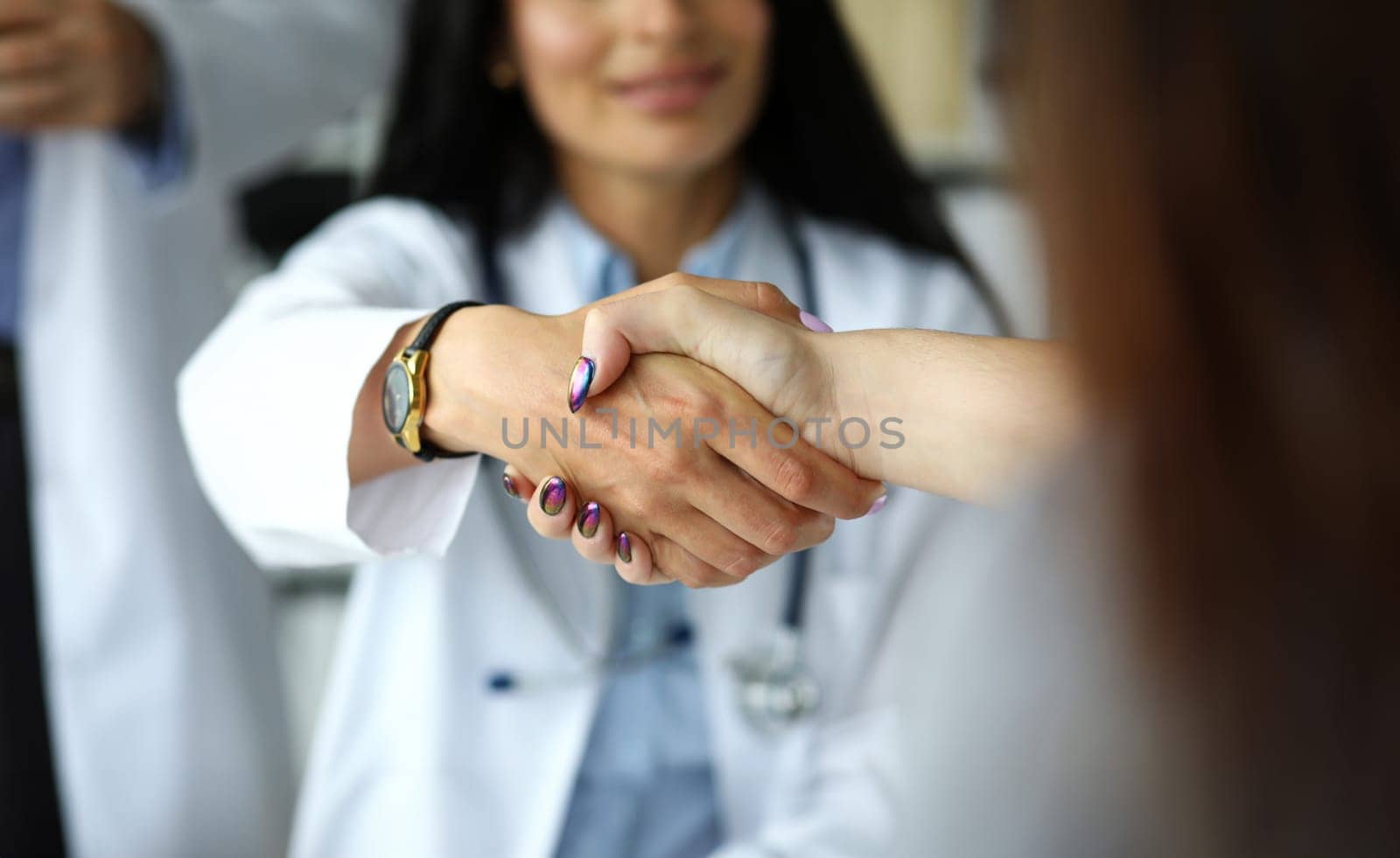 Arm of female GP shaking hands with visitor close-up. Self introduction cheering or problem solution deal concept