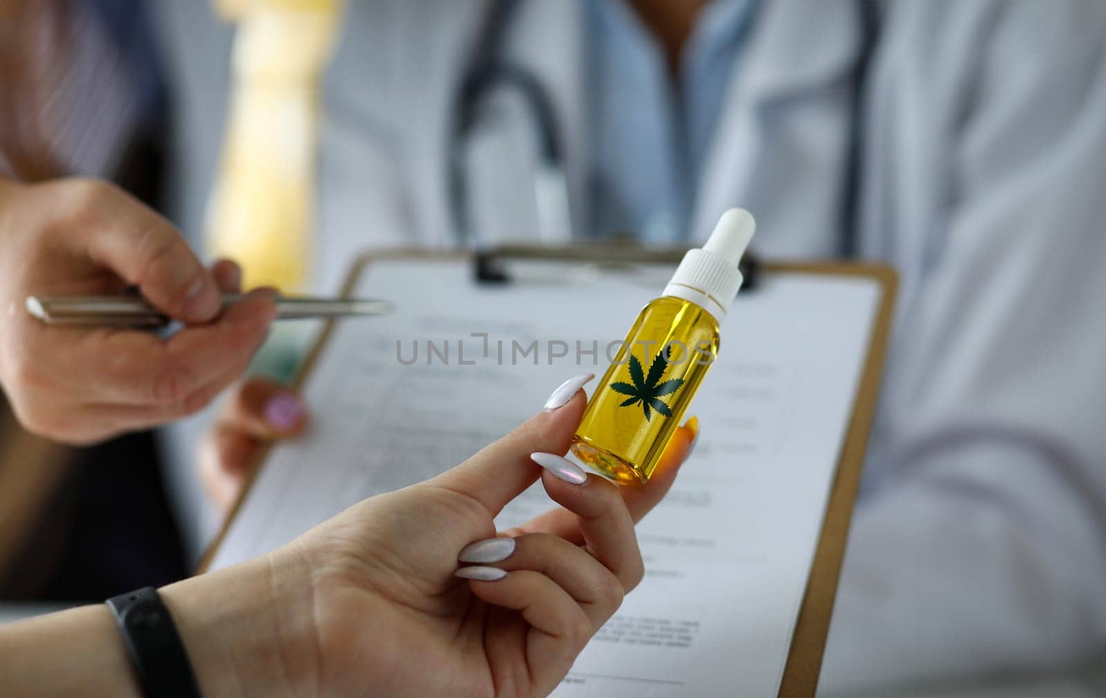 Visitor hand holding jar of cannabis concentrate oil closeup