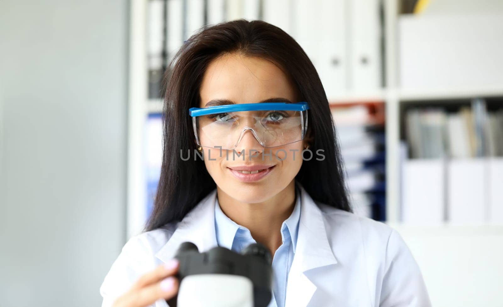 Beautiful female assistant sitting at worktable looking in camera portrait