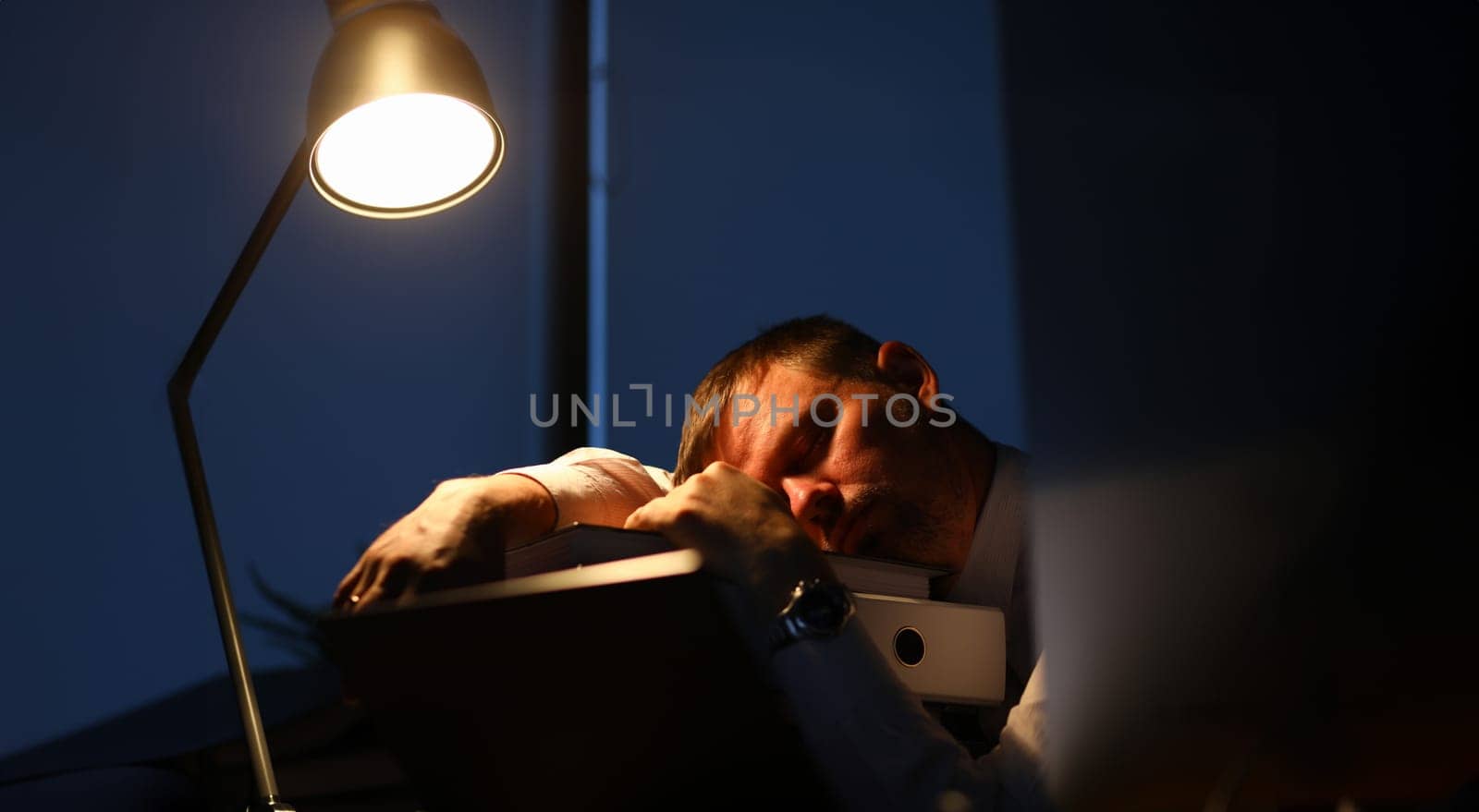 Man sleeping on office table evening time by kuprevich