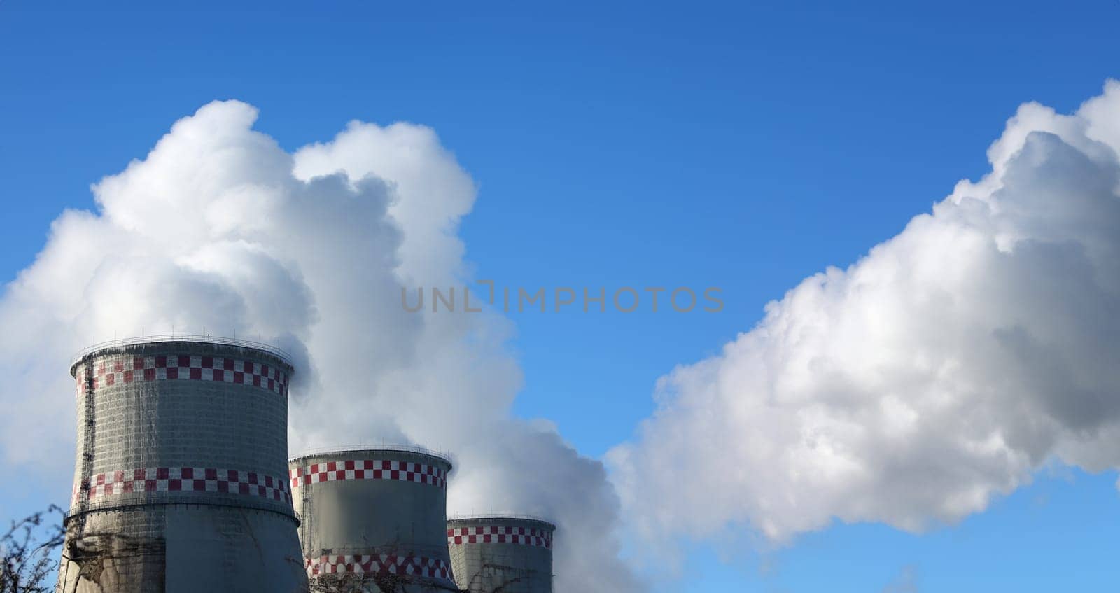 White smoke comes from pipes against blue sky by kuprevich