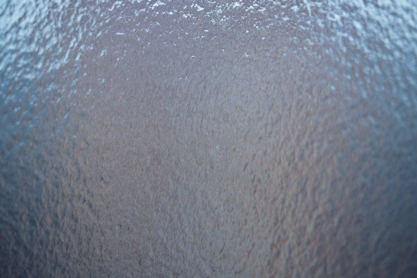 Freezing rain on a window, ice on the windowpane. Frost ice patterns on a window glass. Rime on a windowpane, Bitter cold. Frosted glass window. Ice Background.