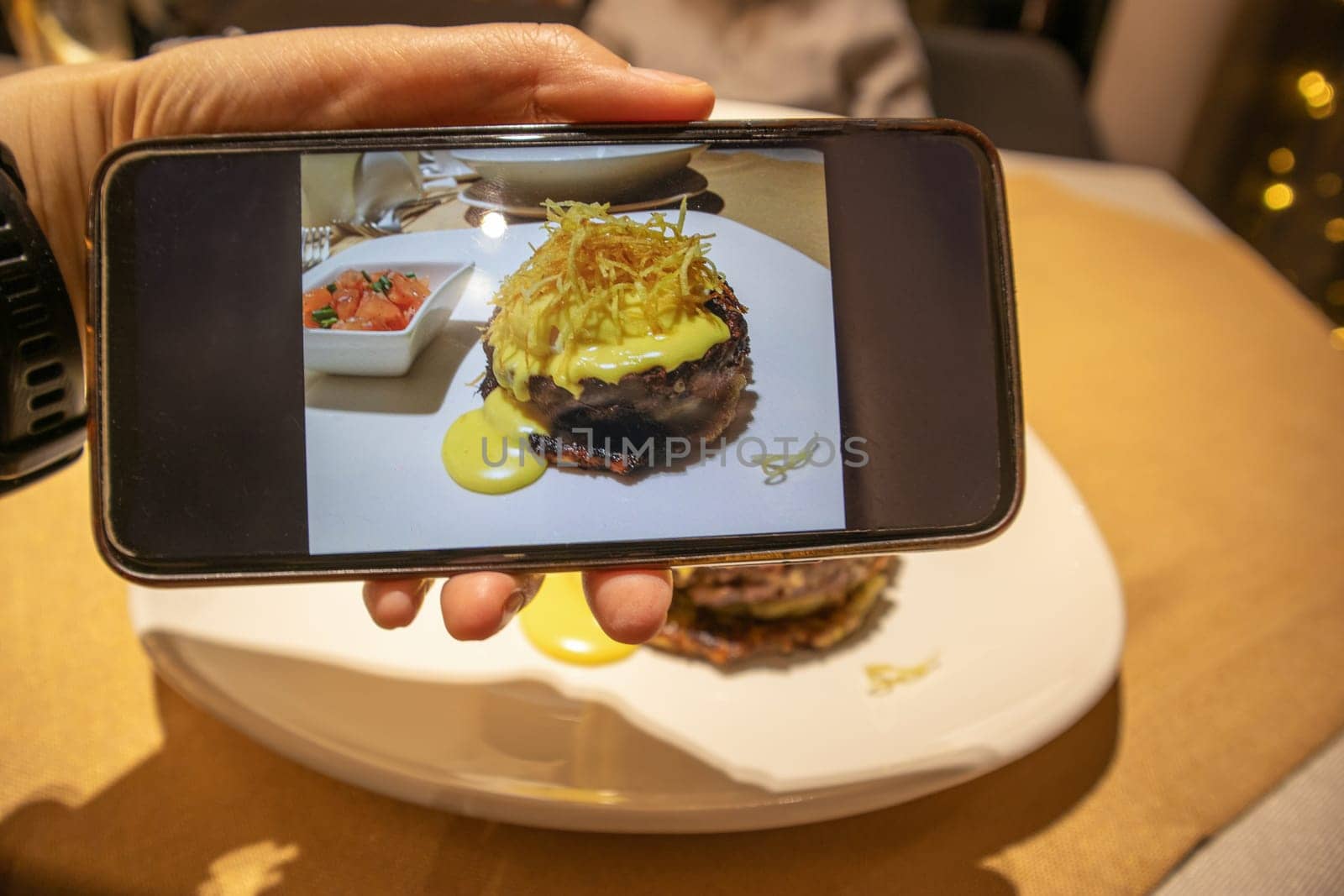 photo of smartphone screen with food served in restaurant. food blogger or food photographer concept. by Leoschka
