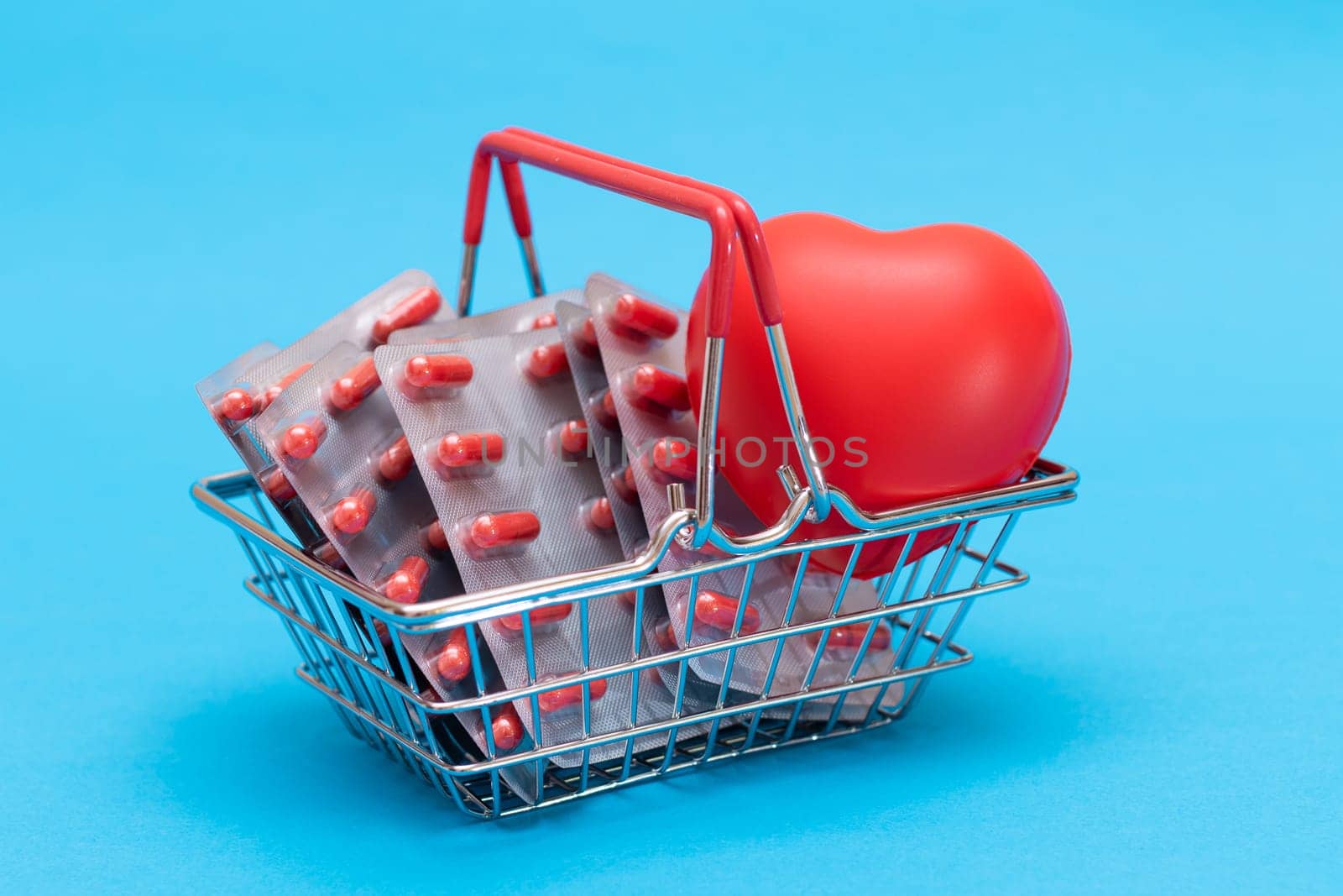 Buying Medicines. Drug Addiction Concept: Pills and Capsules in Shopping Basket on Blue Background. Global Pharmaceutical Industry and Big Pharma. Ordering Pharmaceutical Products