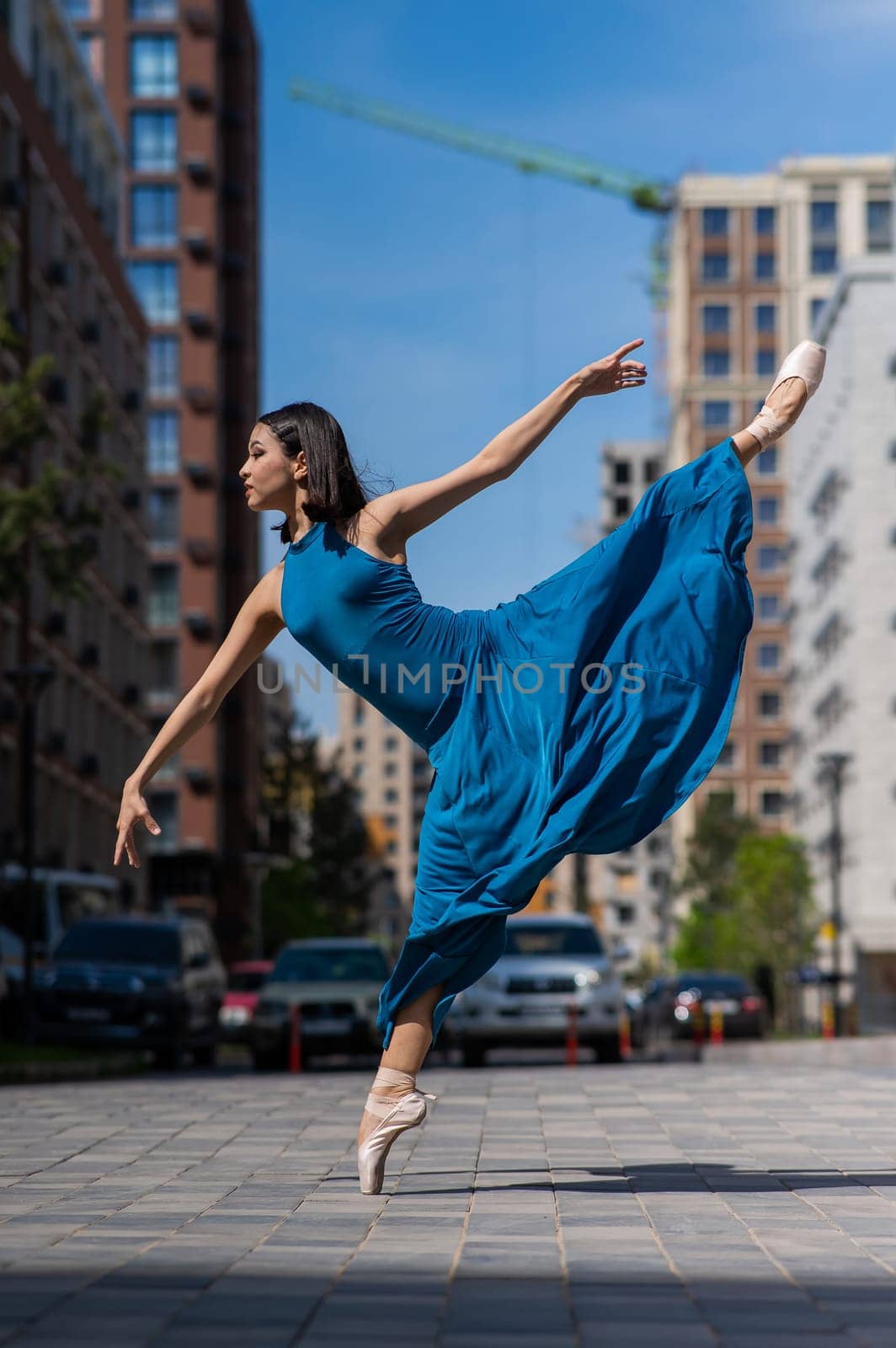 Beautiful Asian ballerina dancing outdoors. Urban landscape