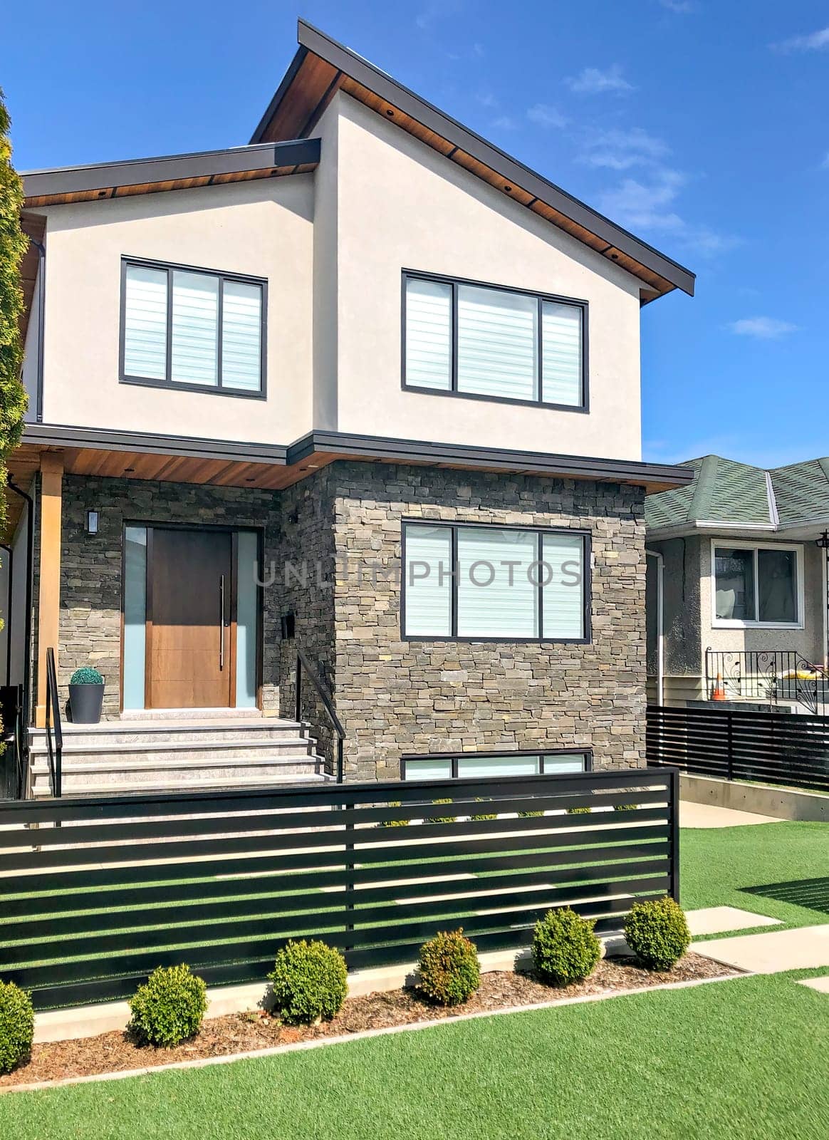 Residential family house with concrete pathway over front yard. Family house on sunny day in British Columbia, Canada