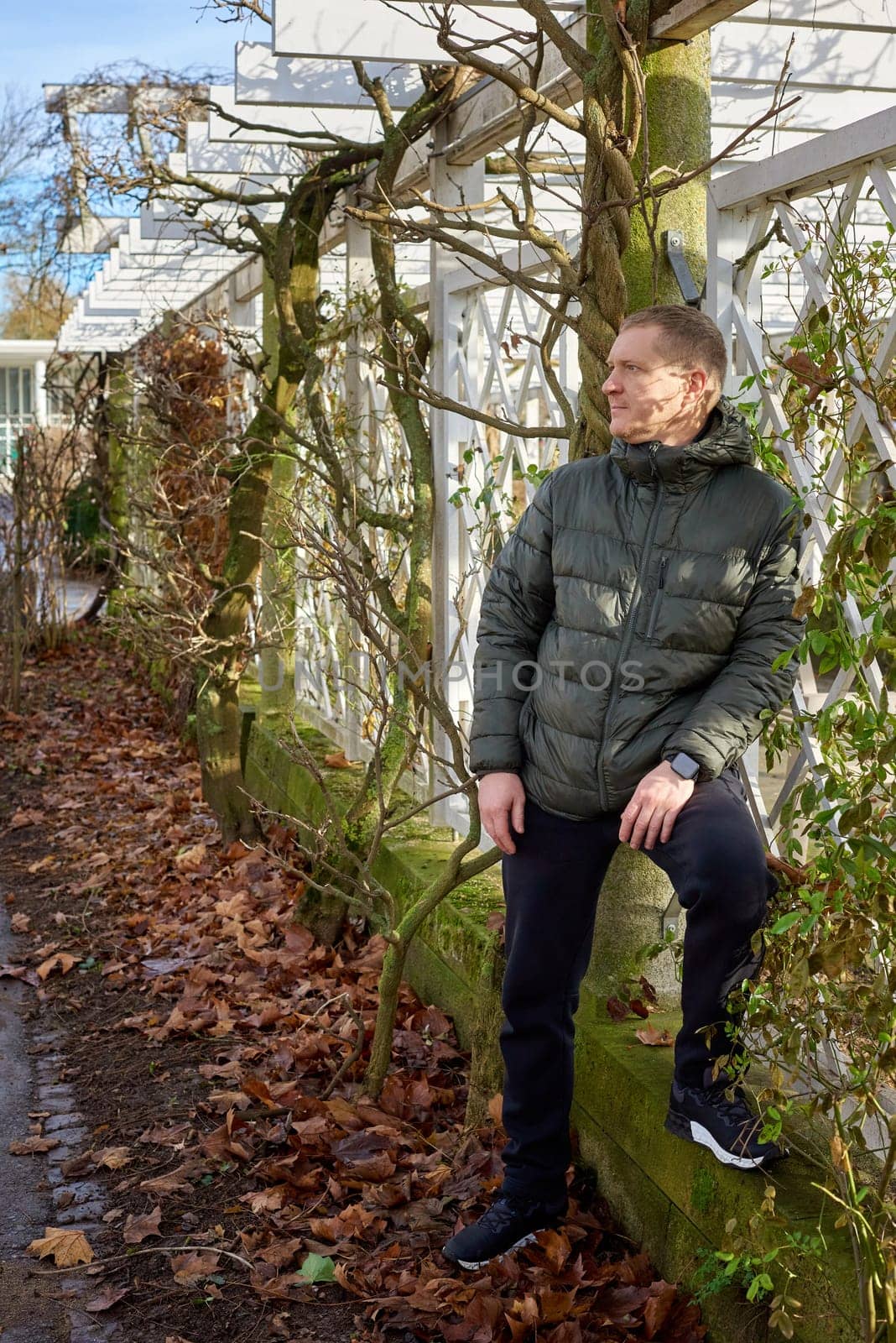 Portrait of handsome man standing outside in autumn weather. Calm Man Outdoors Relaxing And Breathing In Deeply In Autumn Park by Andrii_Ko